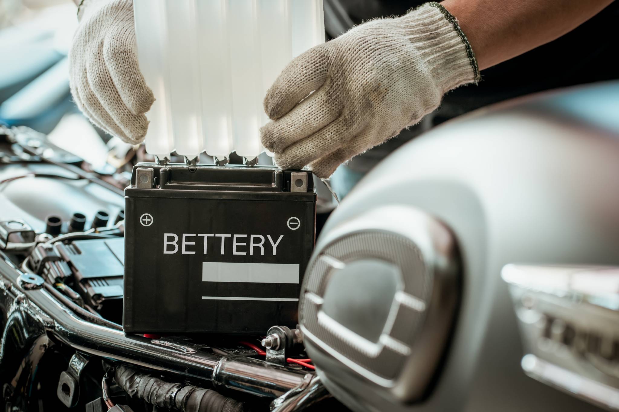 Mechanic removing battery from motorbike