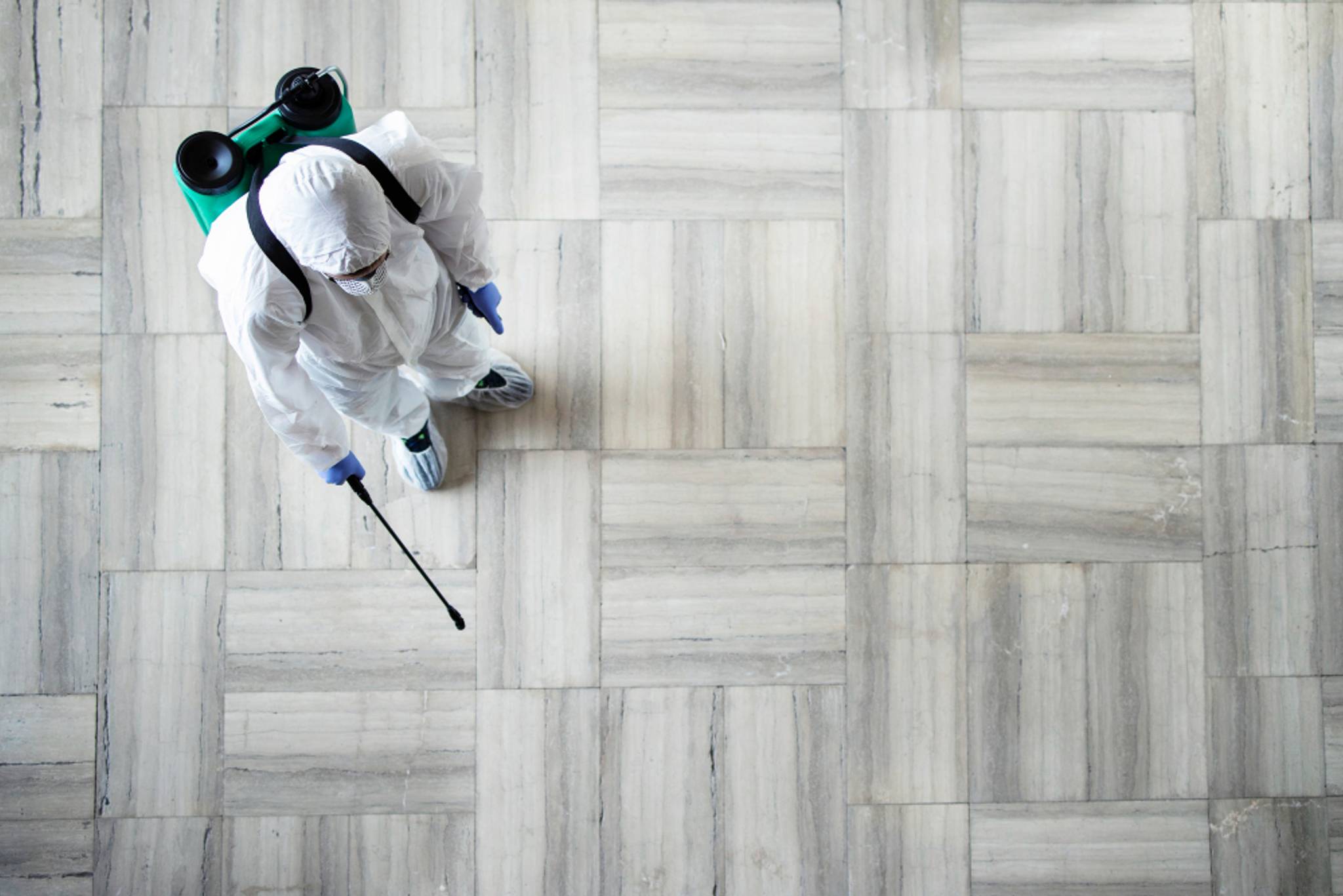 Person in protective clothing cleaning the floor