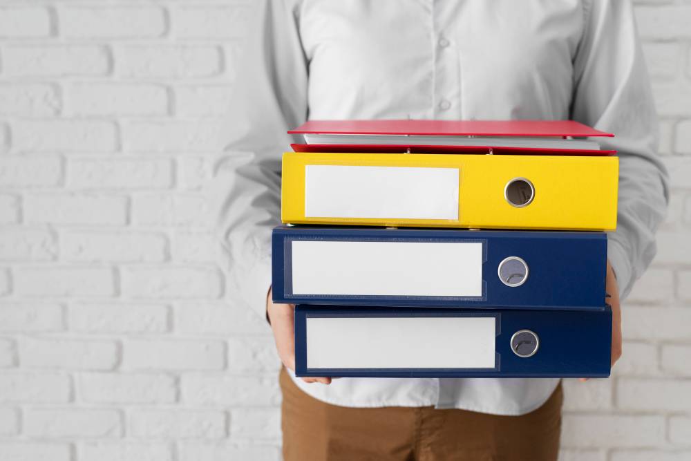 person holding document binders