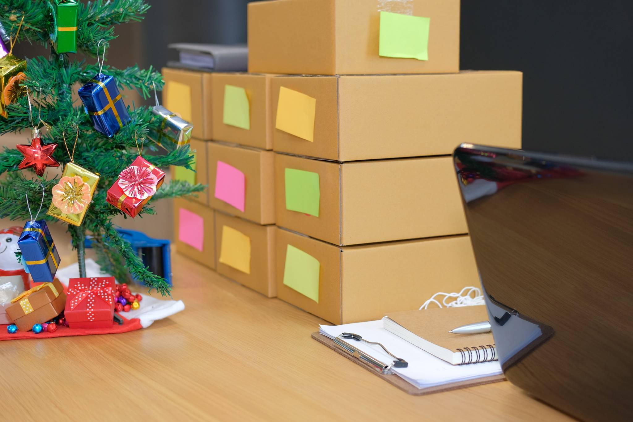 Stack of cardboard boxes with different colored labels.