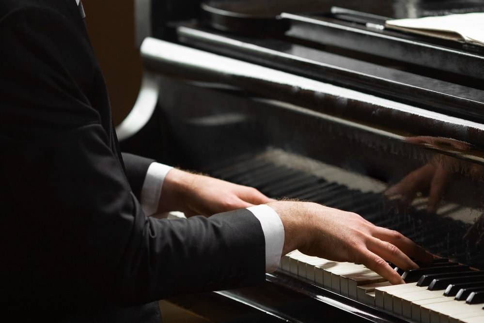 Close up of someones hands as they play piano