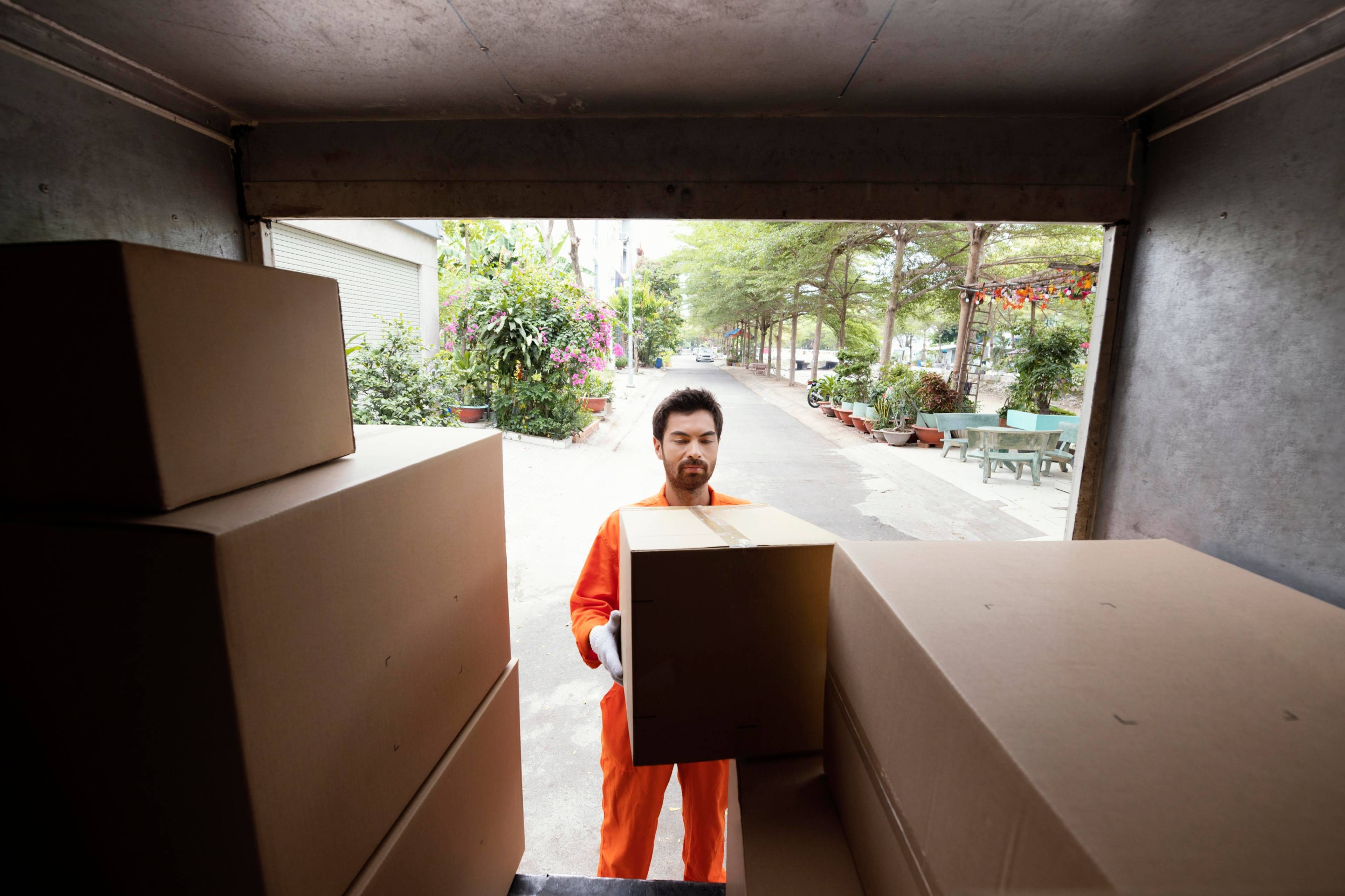 Delivery man loading boxes into a moving truck