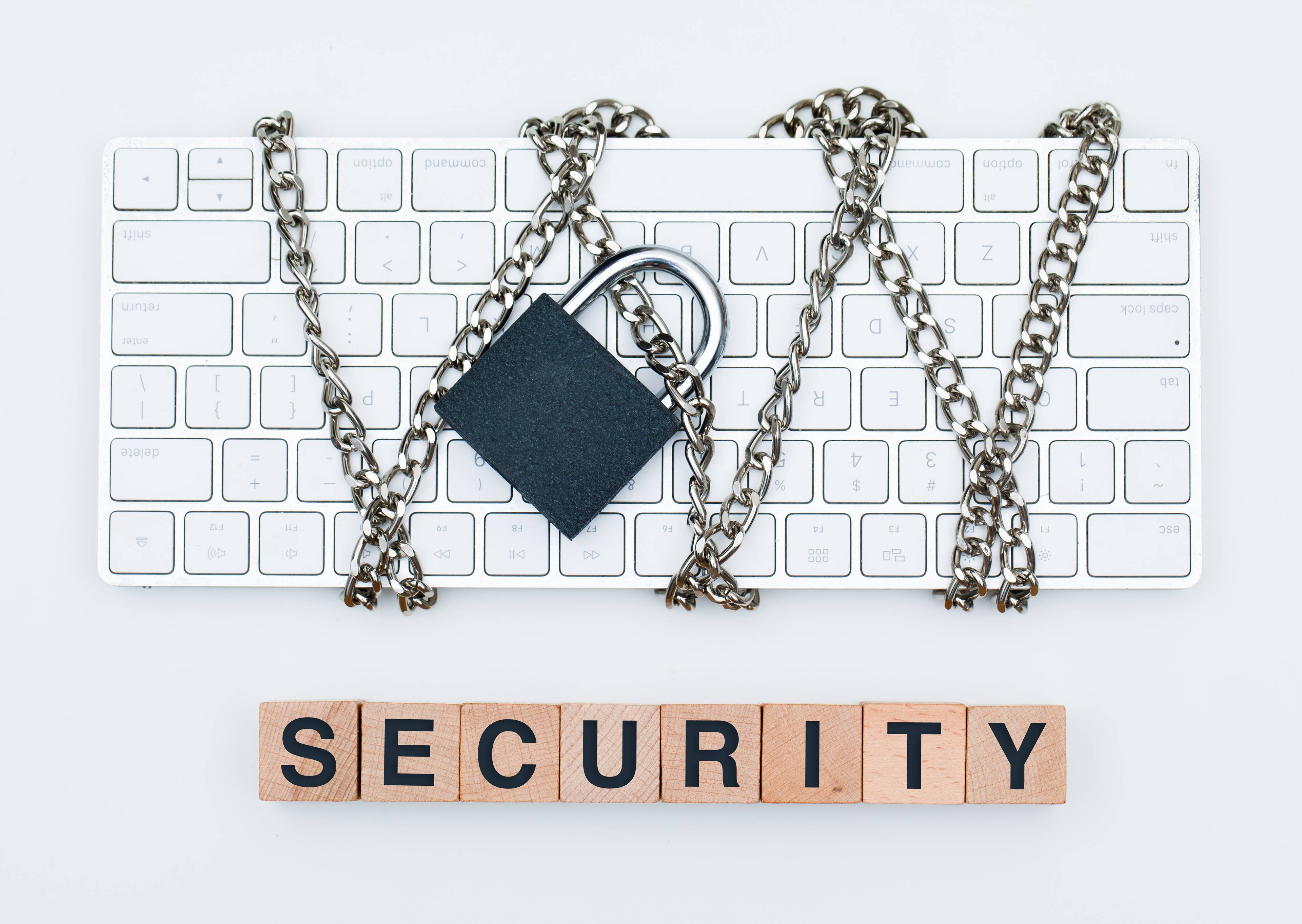 A keyboard chained with the word "security" spelled out