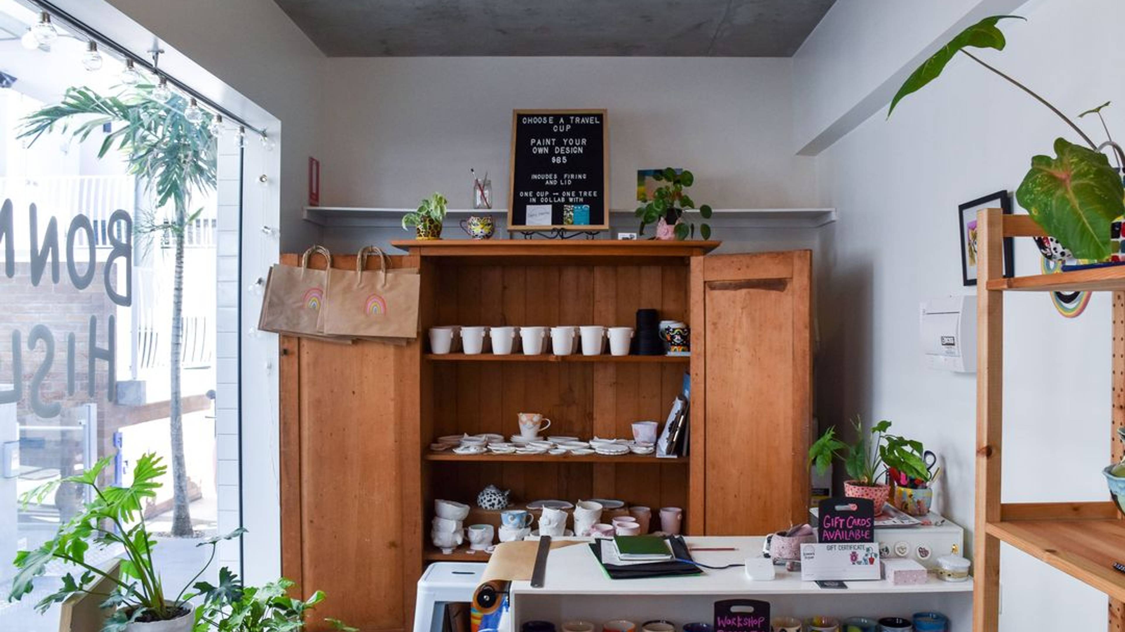 A room with a cabinet, plants, shelves