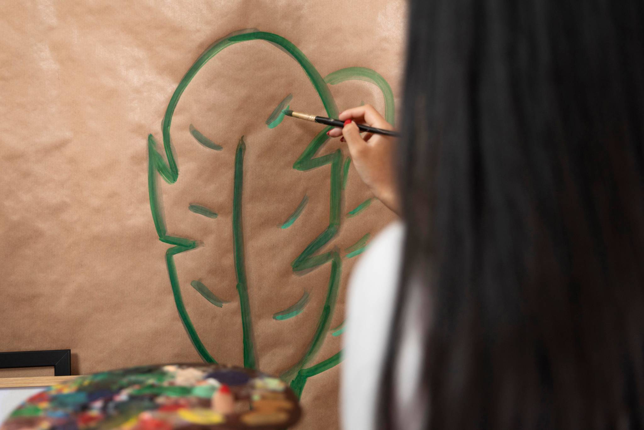Woman painting leaf onto cardboard box