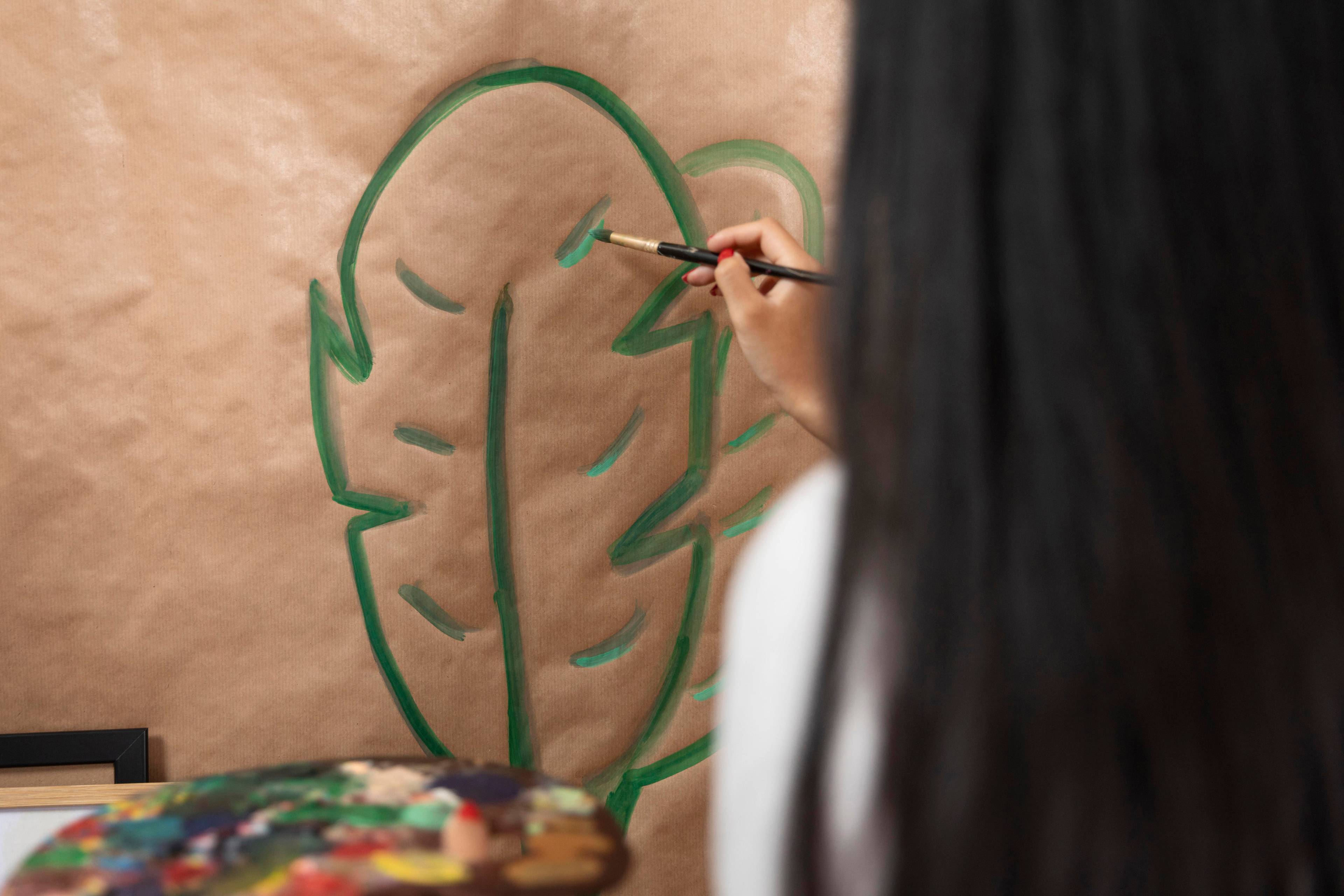 Woman painting leaf onto cardboard box