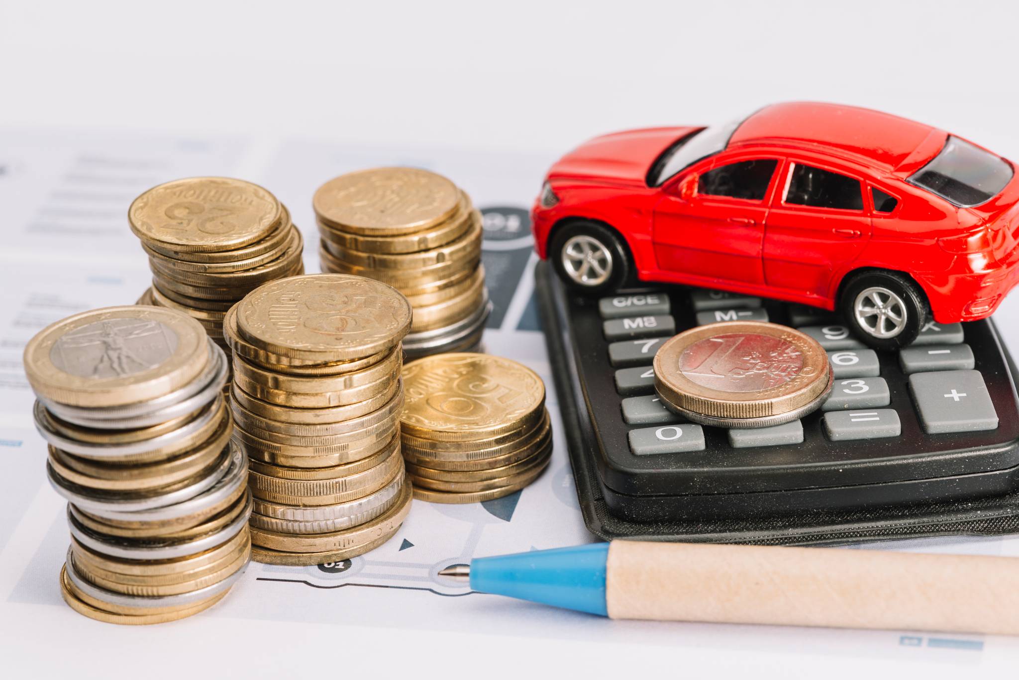 Stack of coins, calculator and toy car