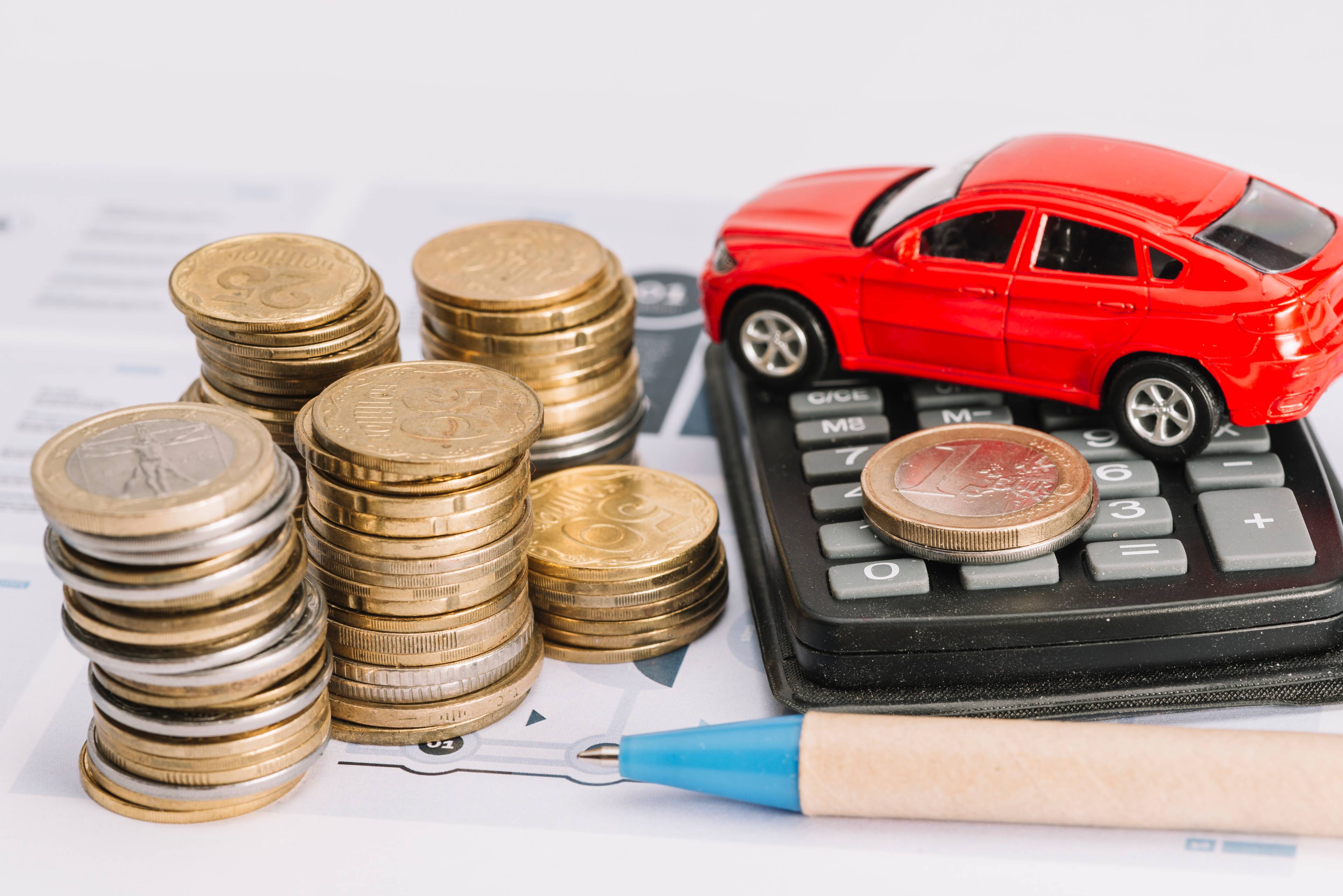 Stack of coins, calculator and toy car
