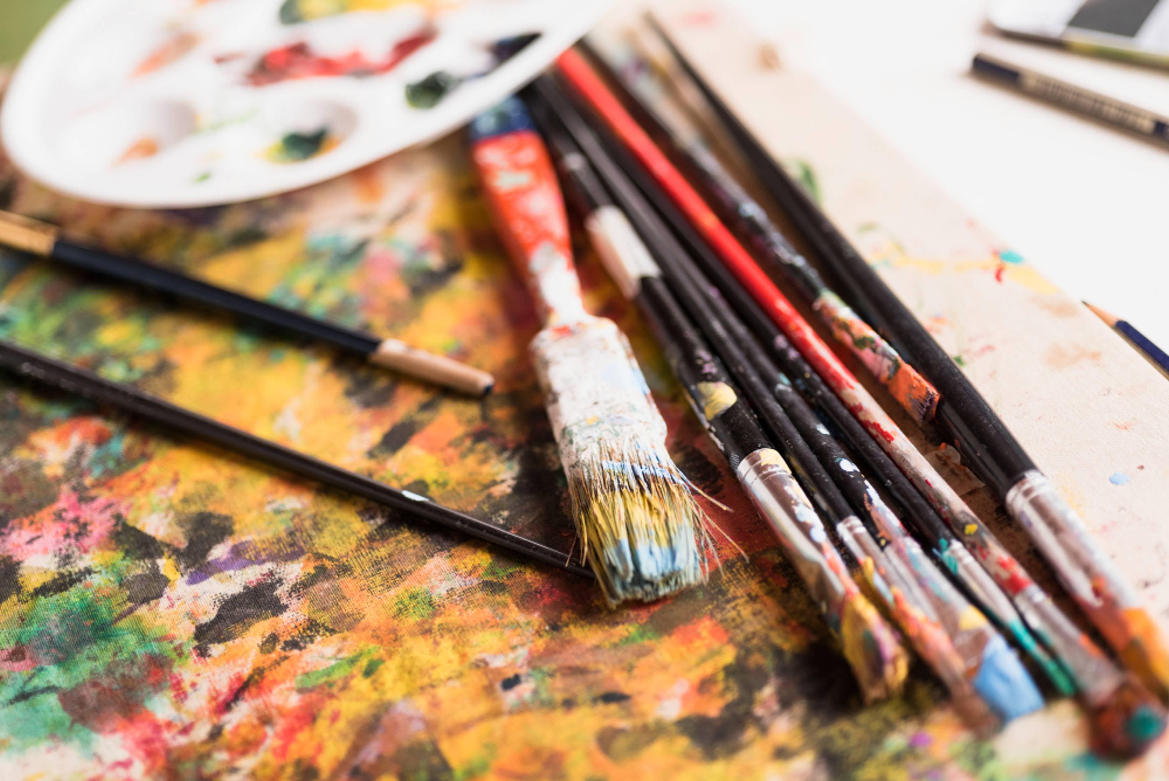 Used paint brushes on a wooden board