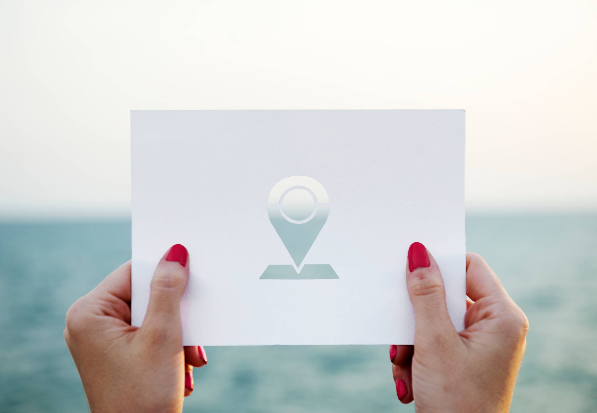 Female holding stencil with location icon.