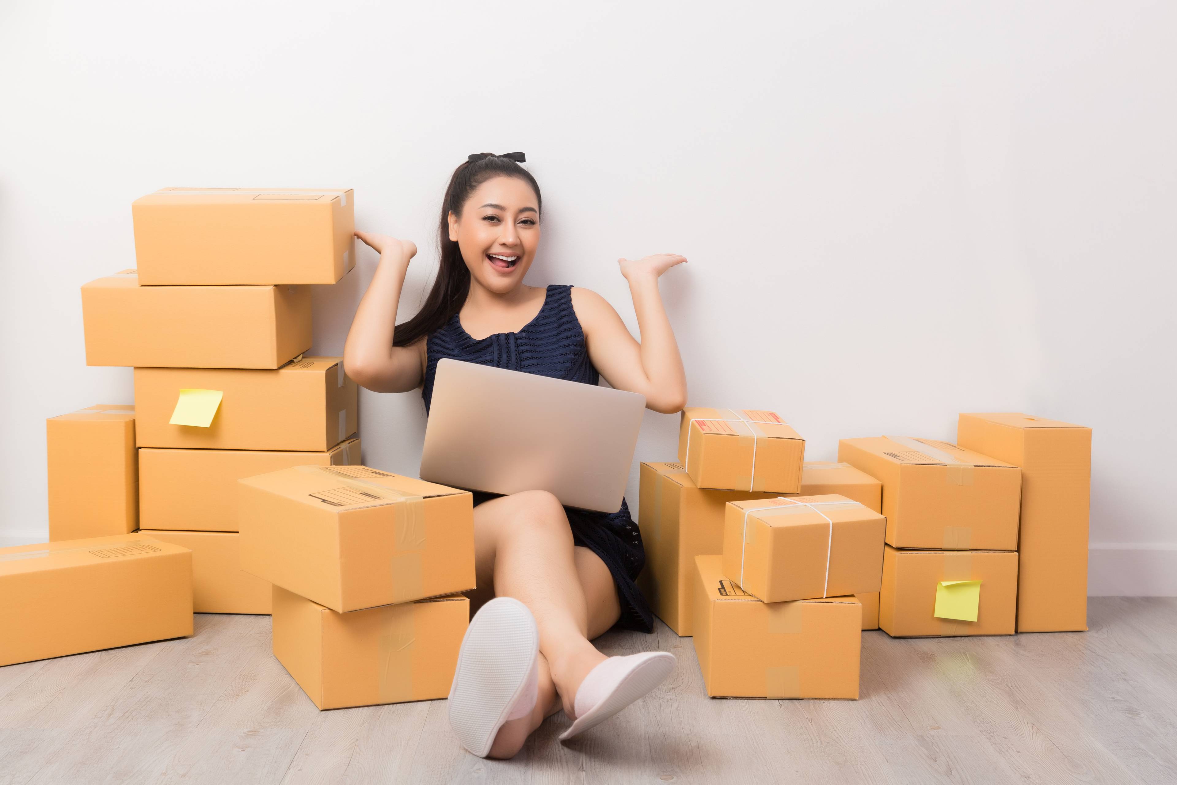 Woman sitting on the floor, surrounded by cardboard boxes