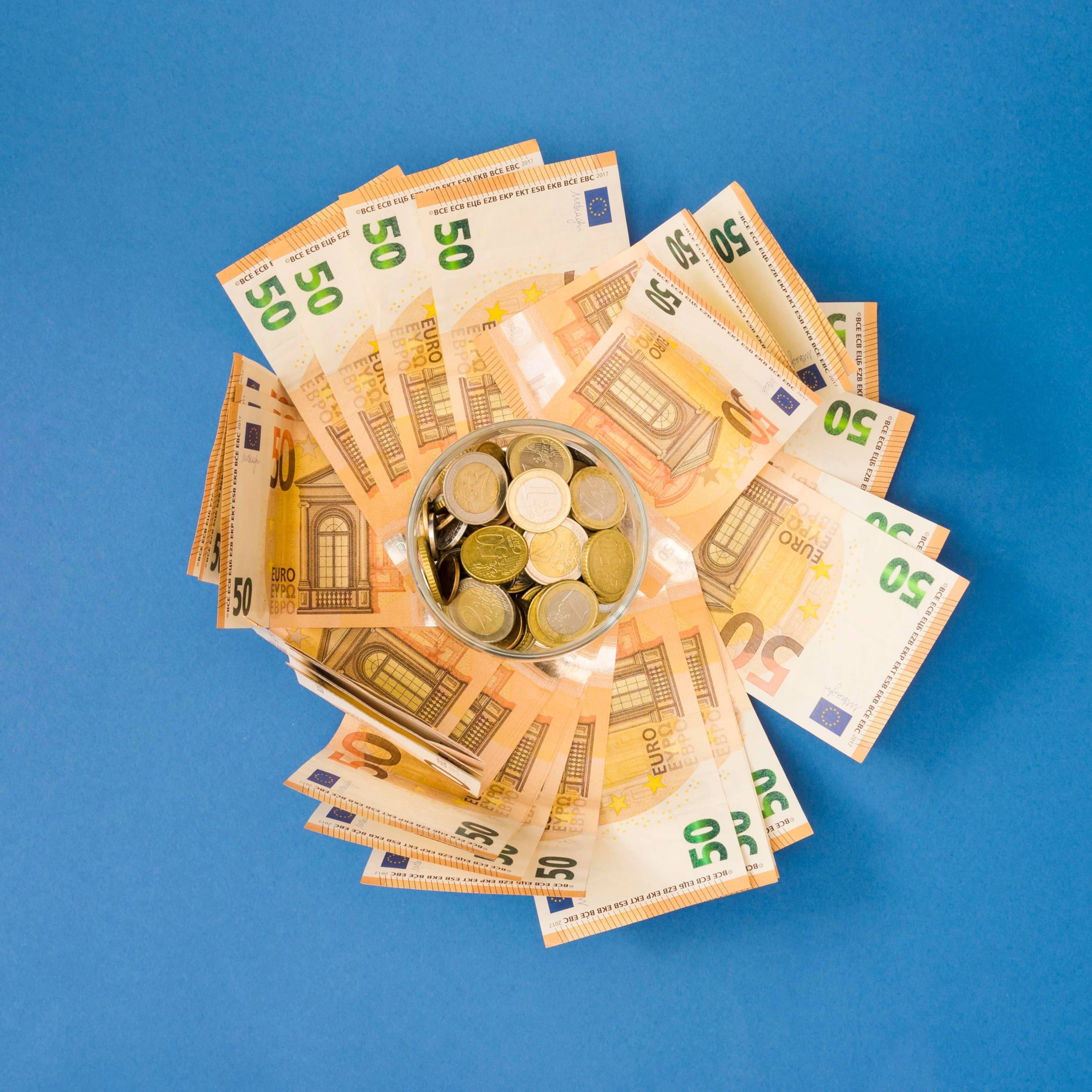 Top view of money arranged circularly with coins in the middle.