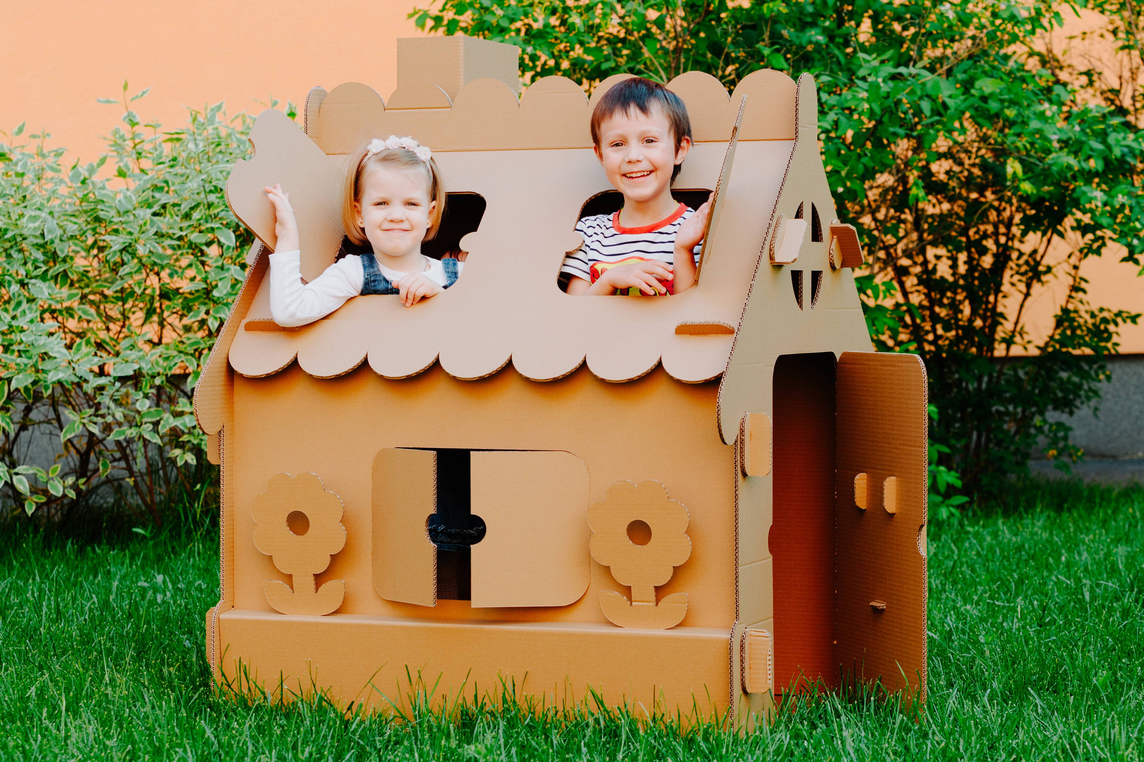 Children playing in cardboard house