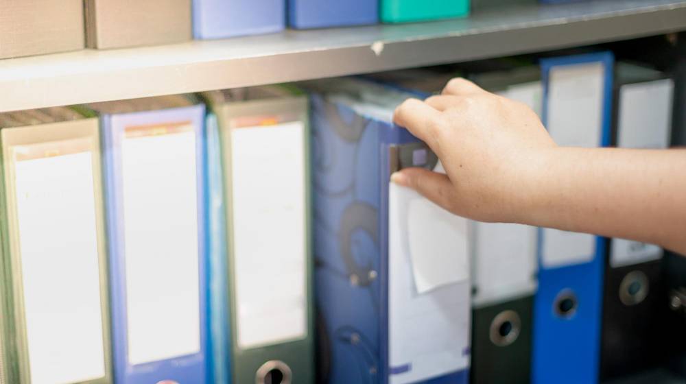 document storage hand reaching for binder