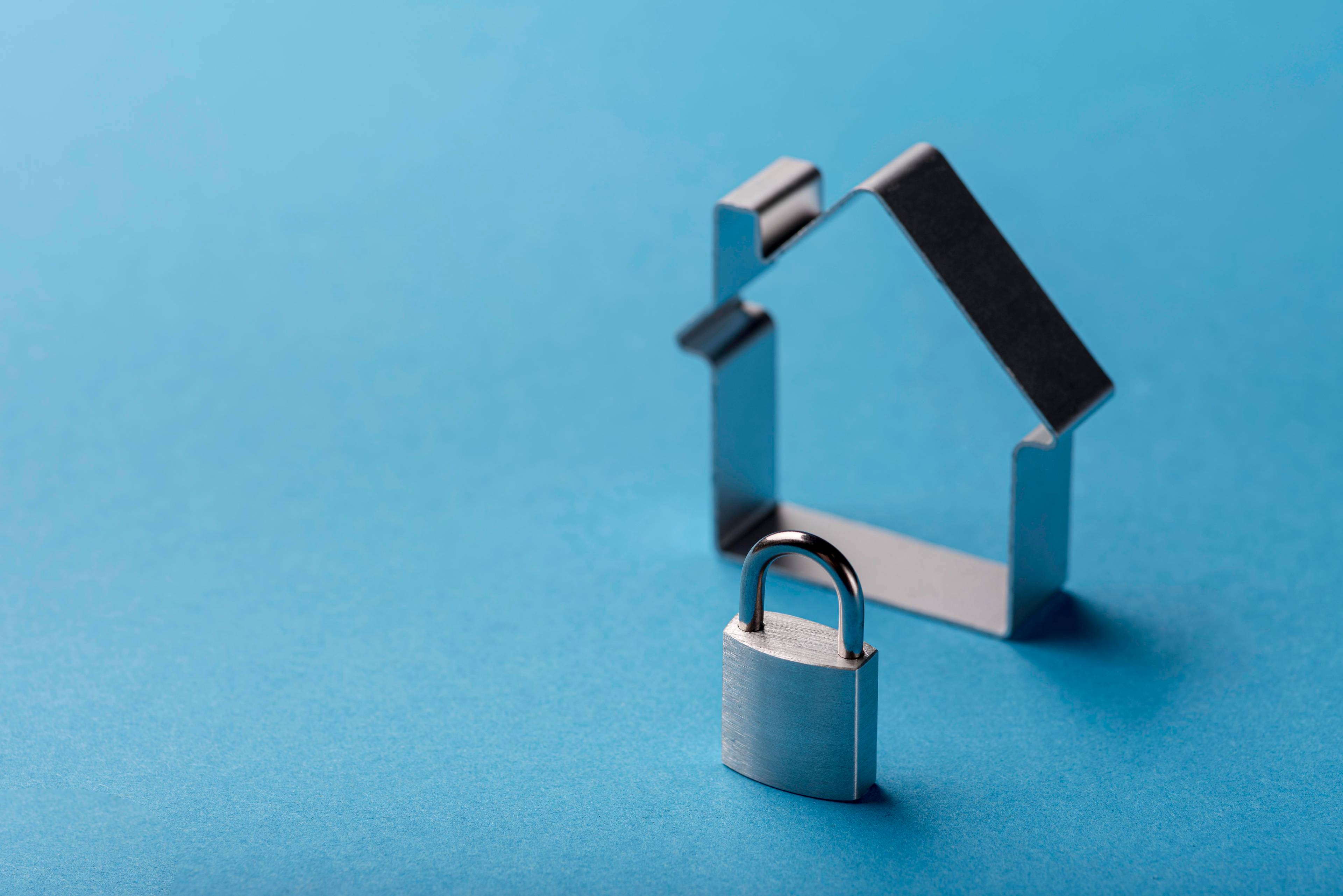 Padlock next to steel model outline of house