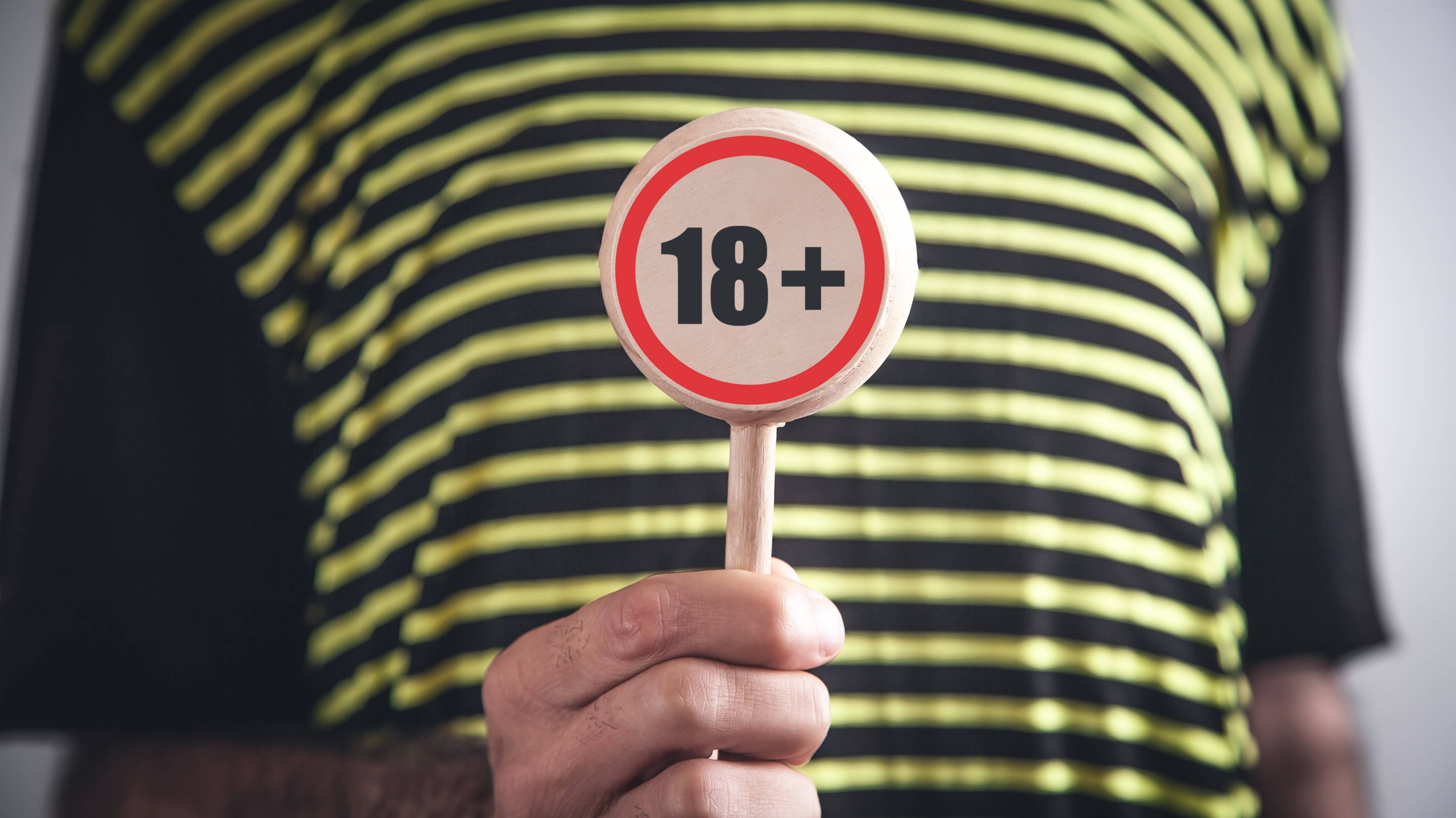 man showing 18 plus symbol