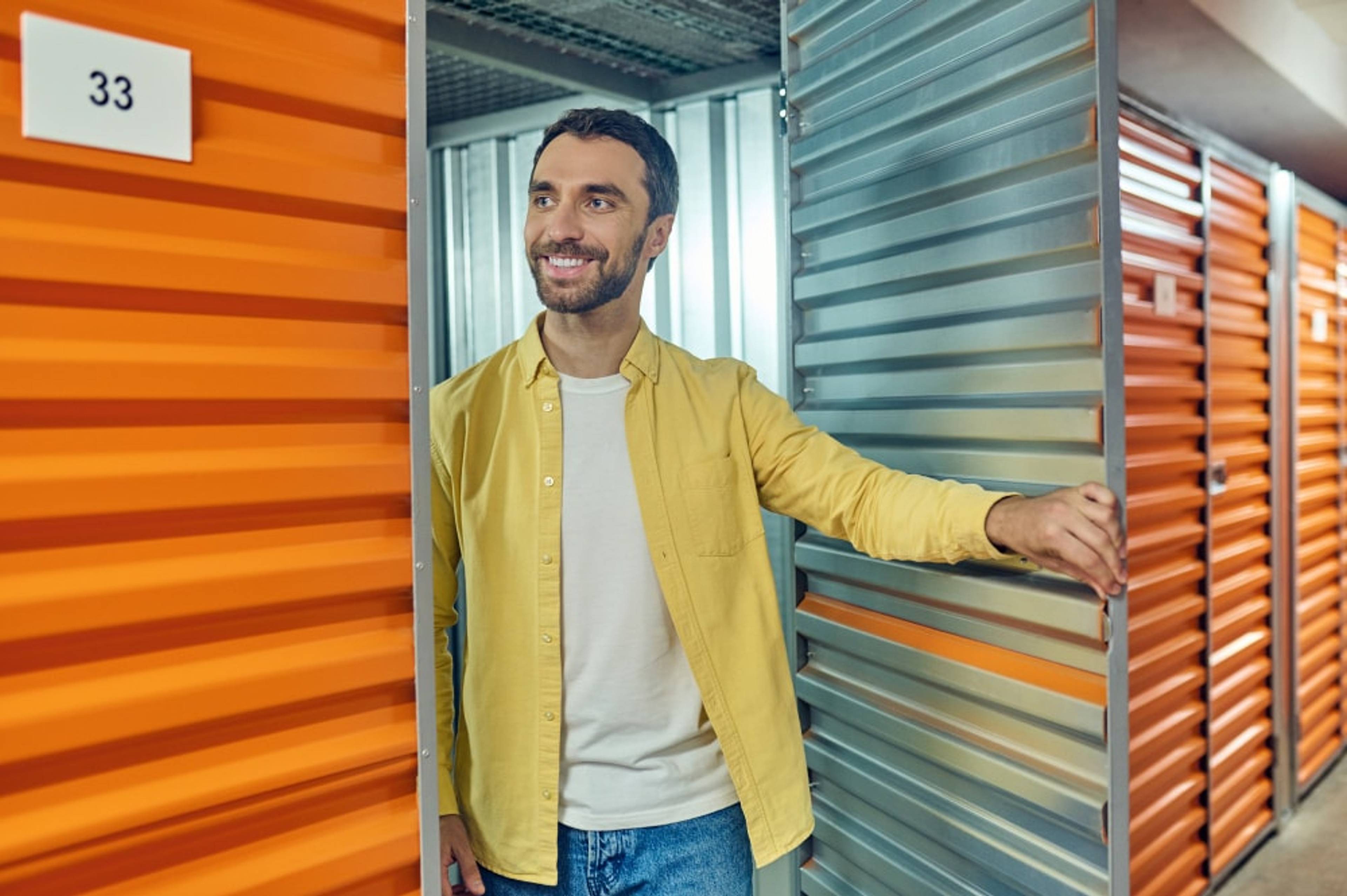A person smiling as they leave a storage unit