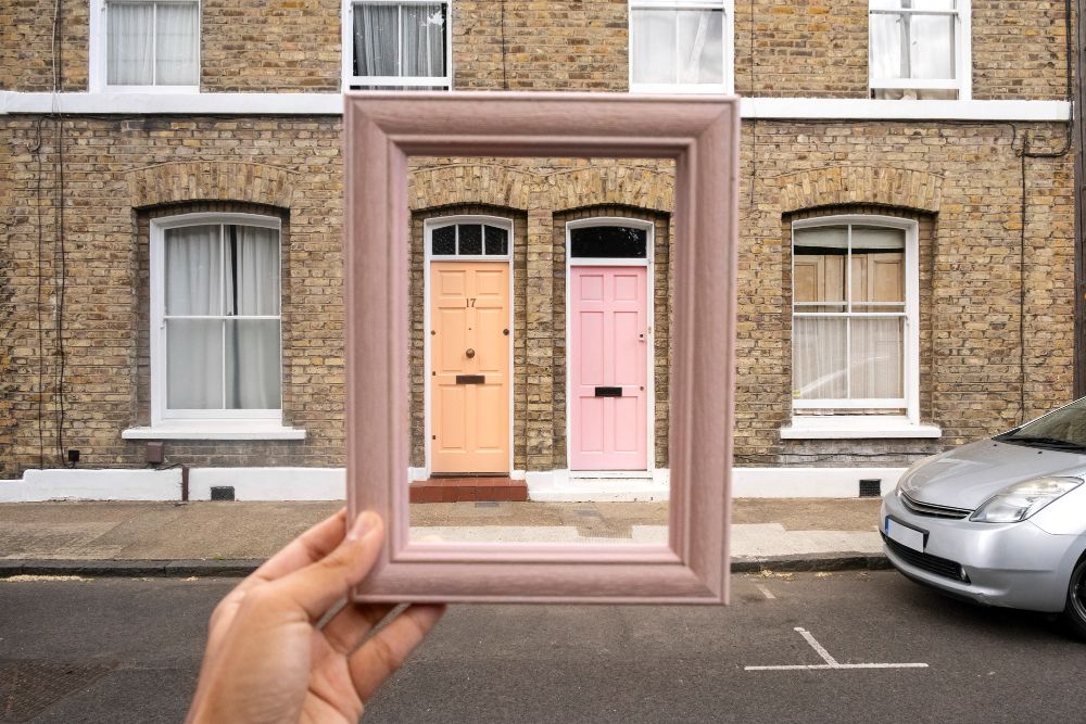 hand holding frame over london terraced homes