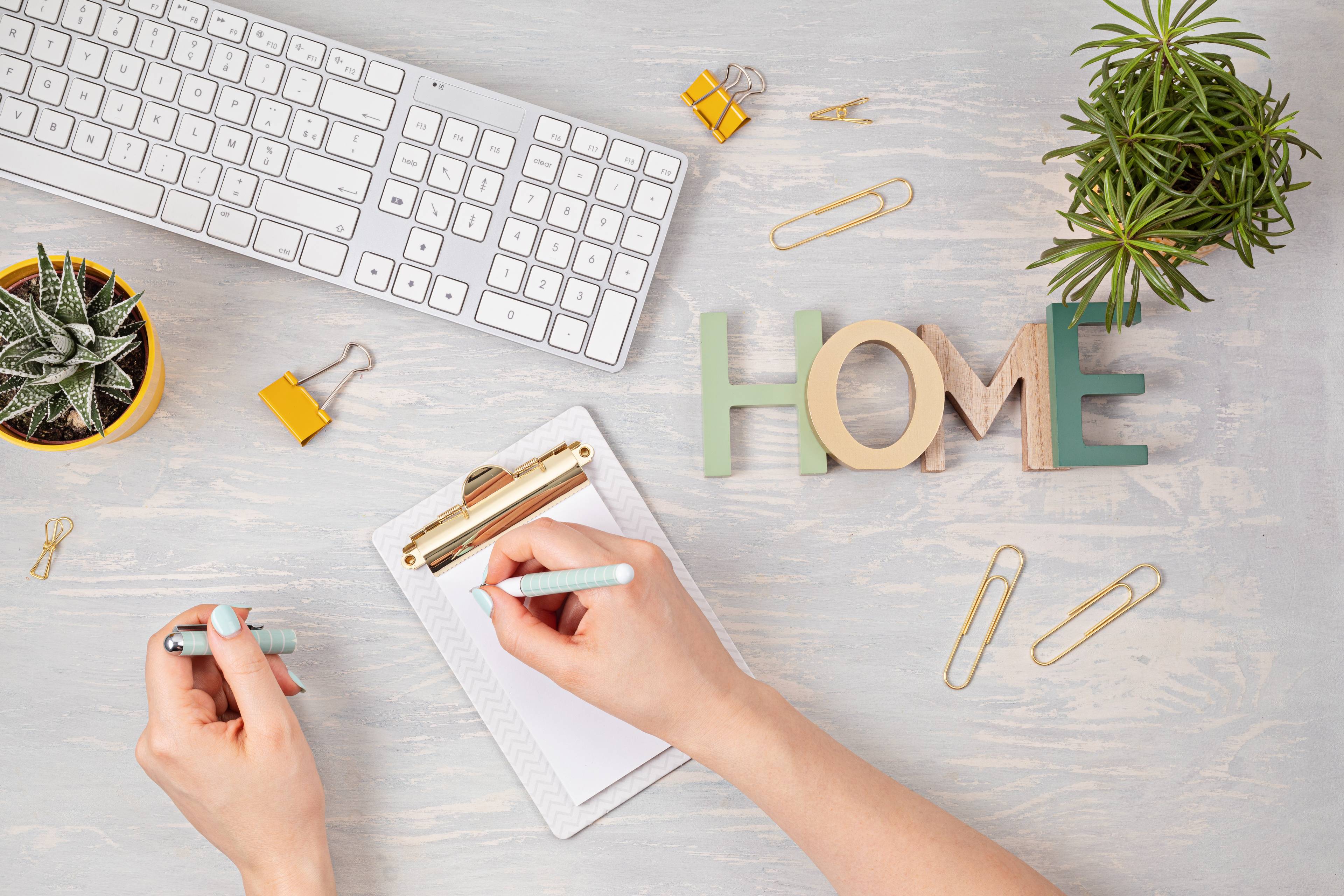 Top view of woman writing on notepad