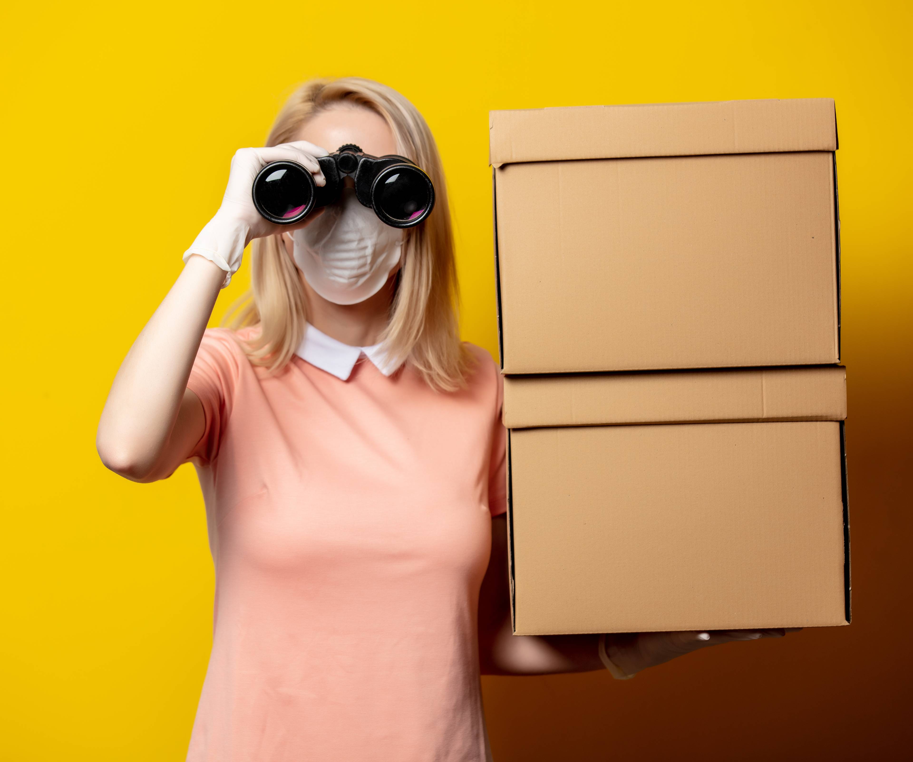 woman with binoculars next to boxes