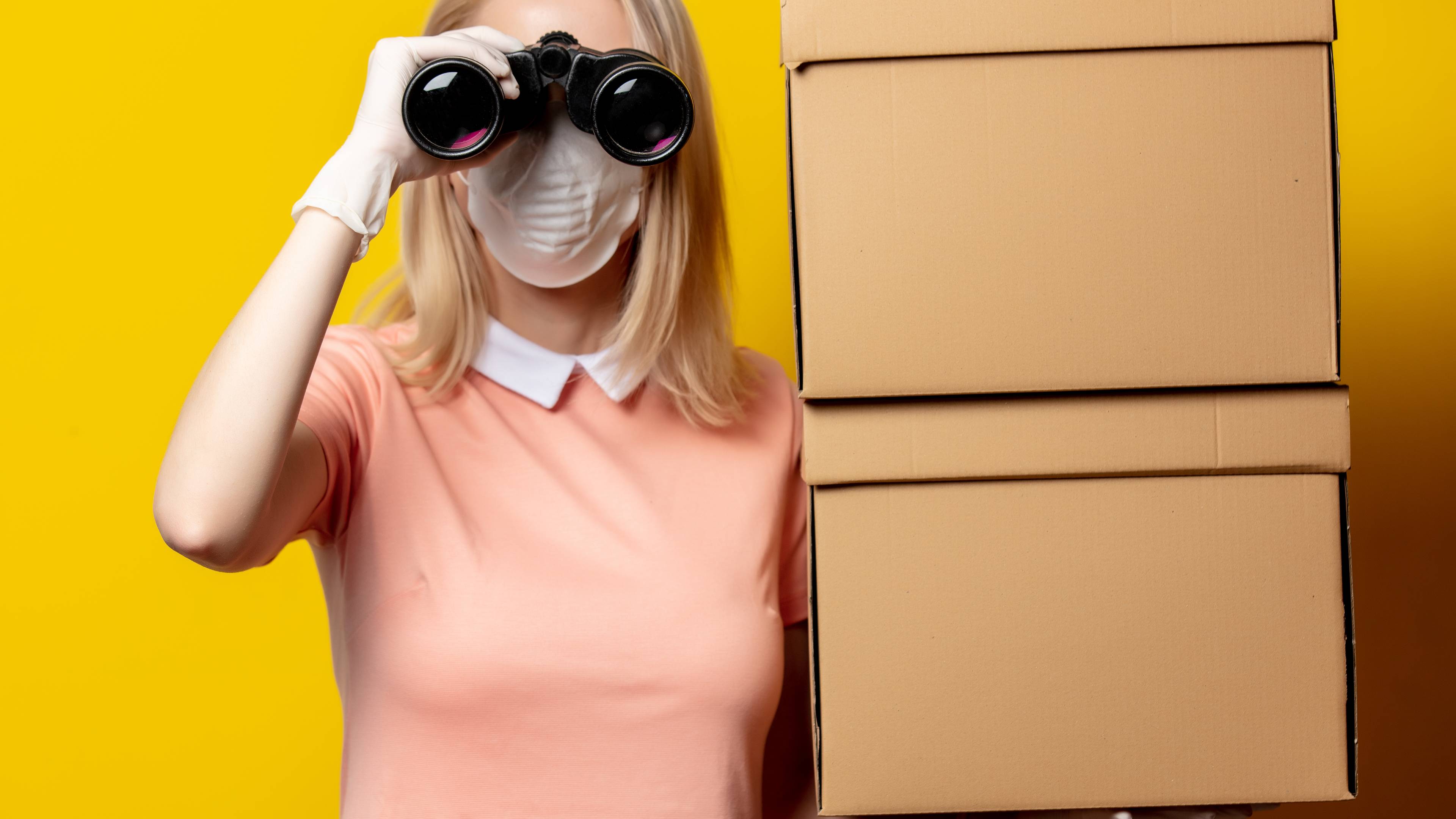 woman with binoculars next to boxes