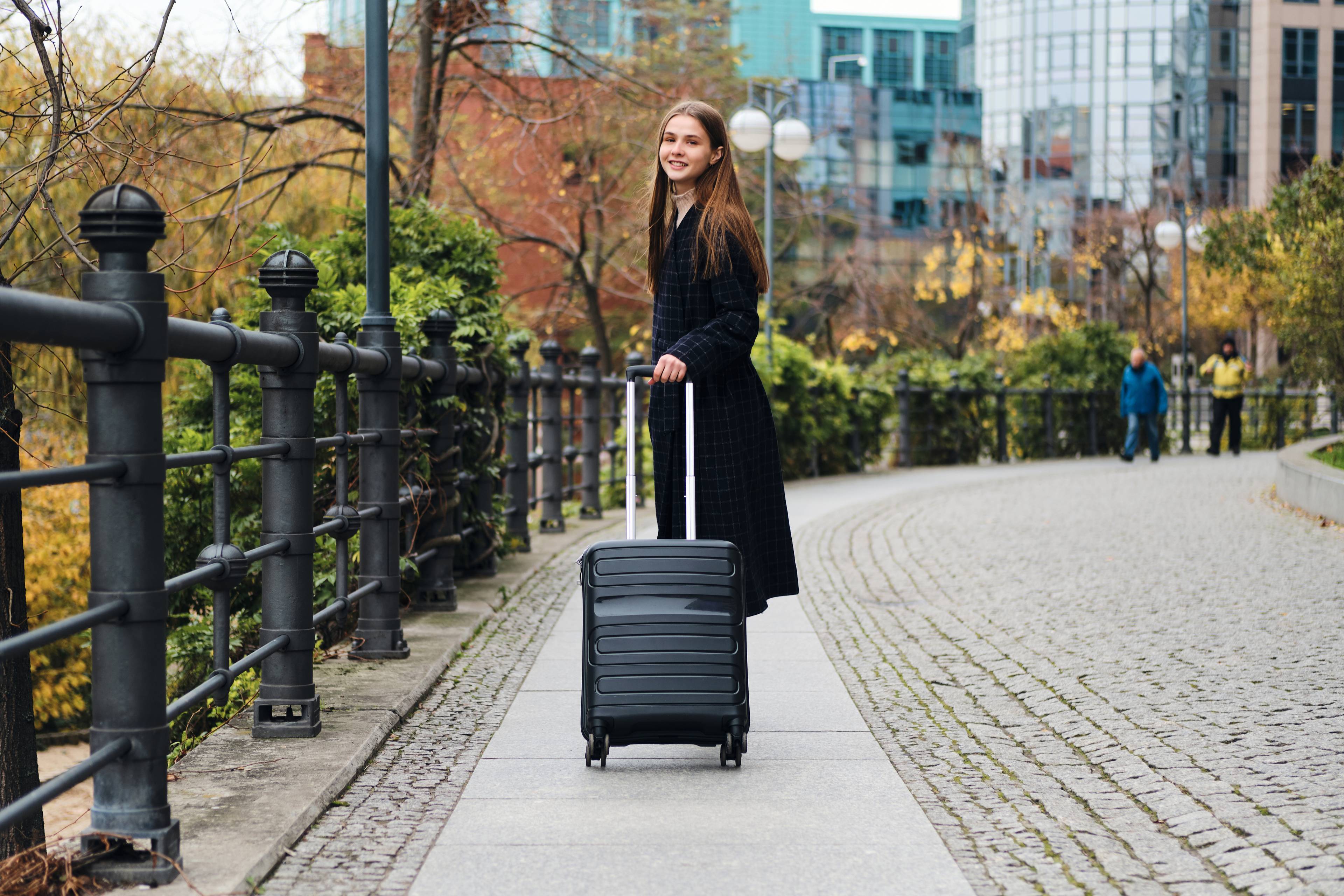 stylish girl with luggage in park