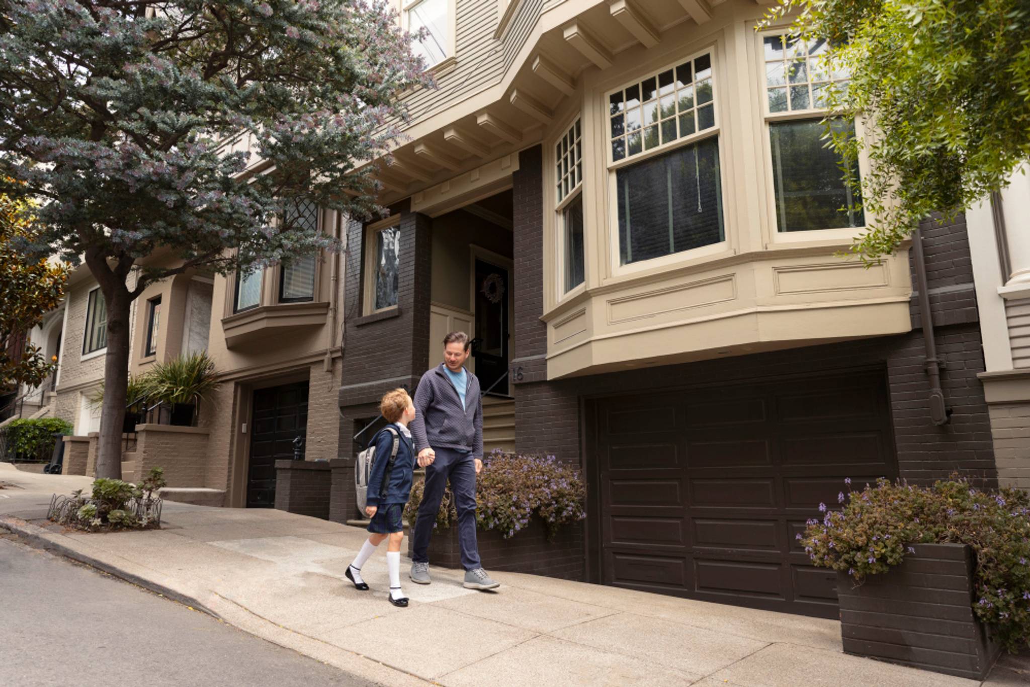 Dad walking his kid to school outside large uk houses