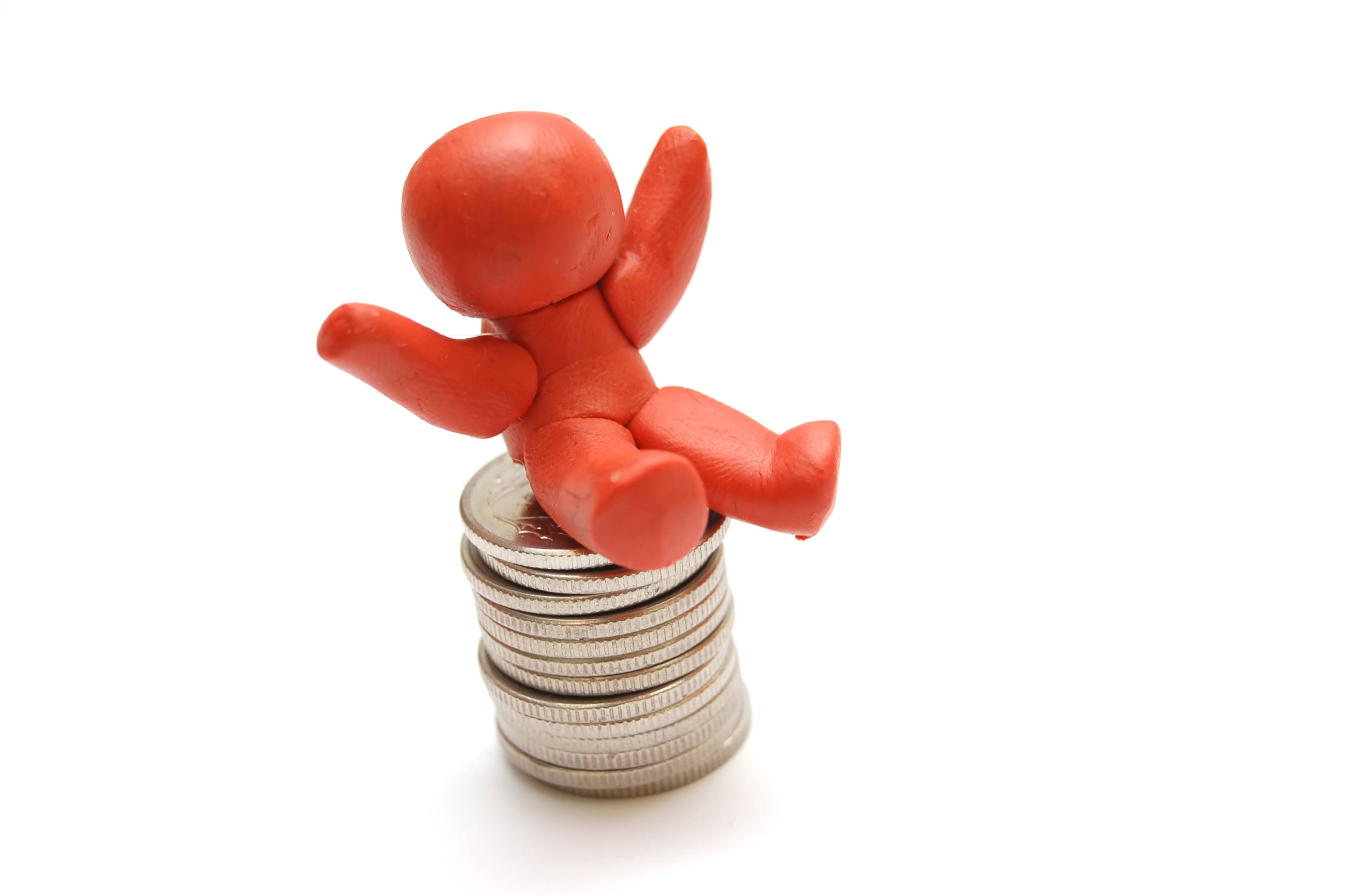 doll sitting on pile of coins
