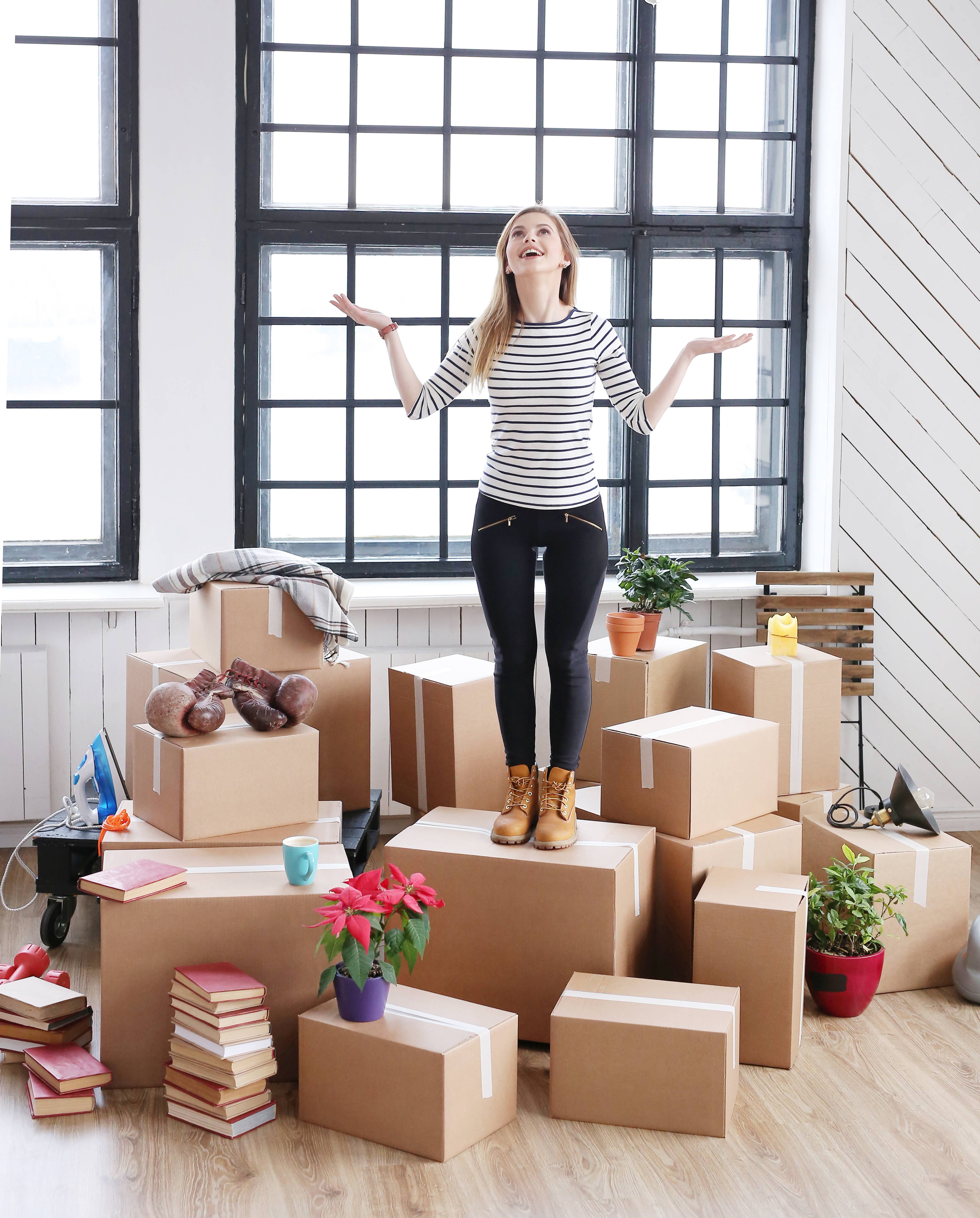 Woman standing on top of pile of boxes