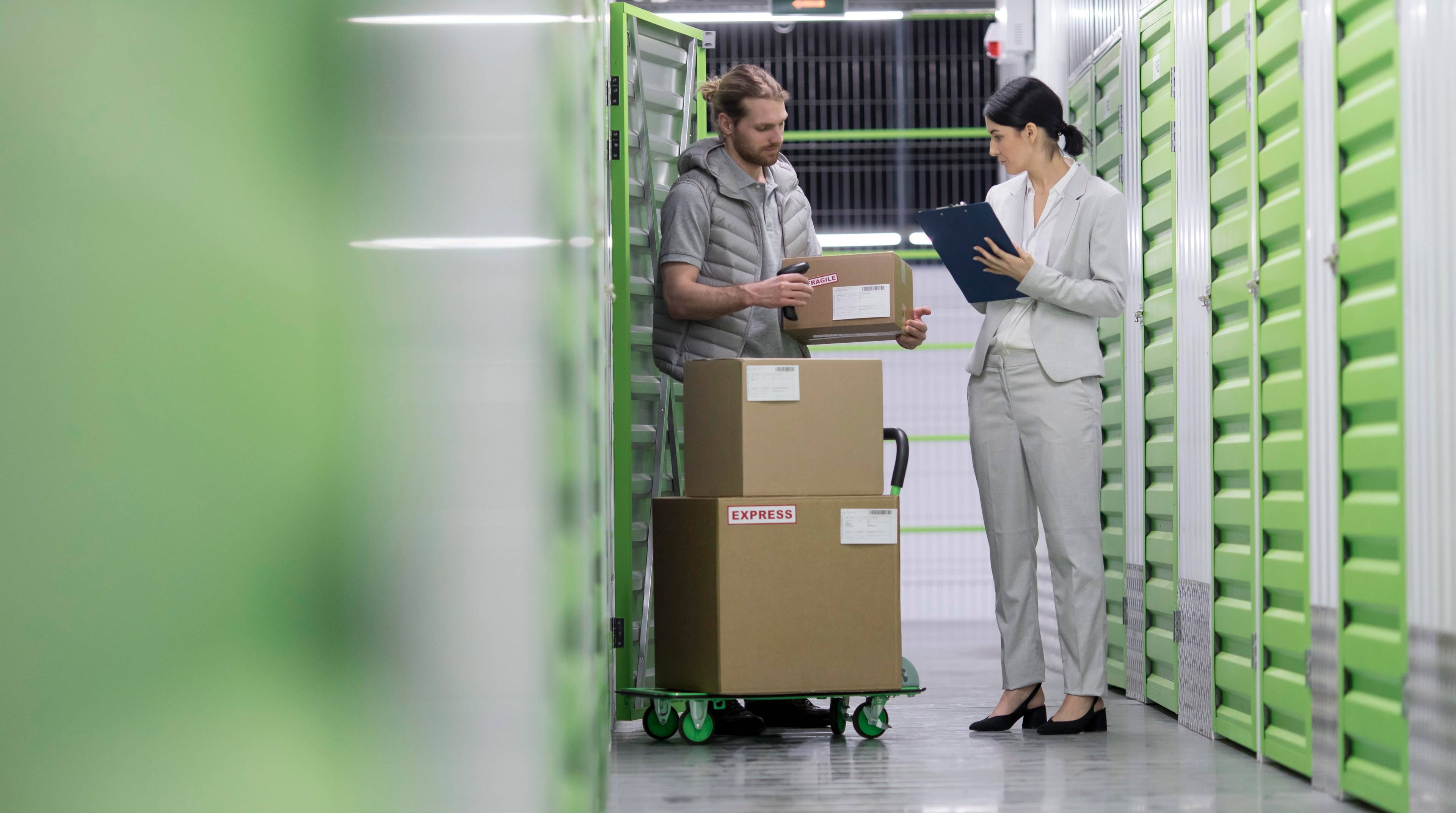 Man talking with female staff in a storage facility.