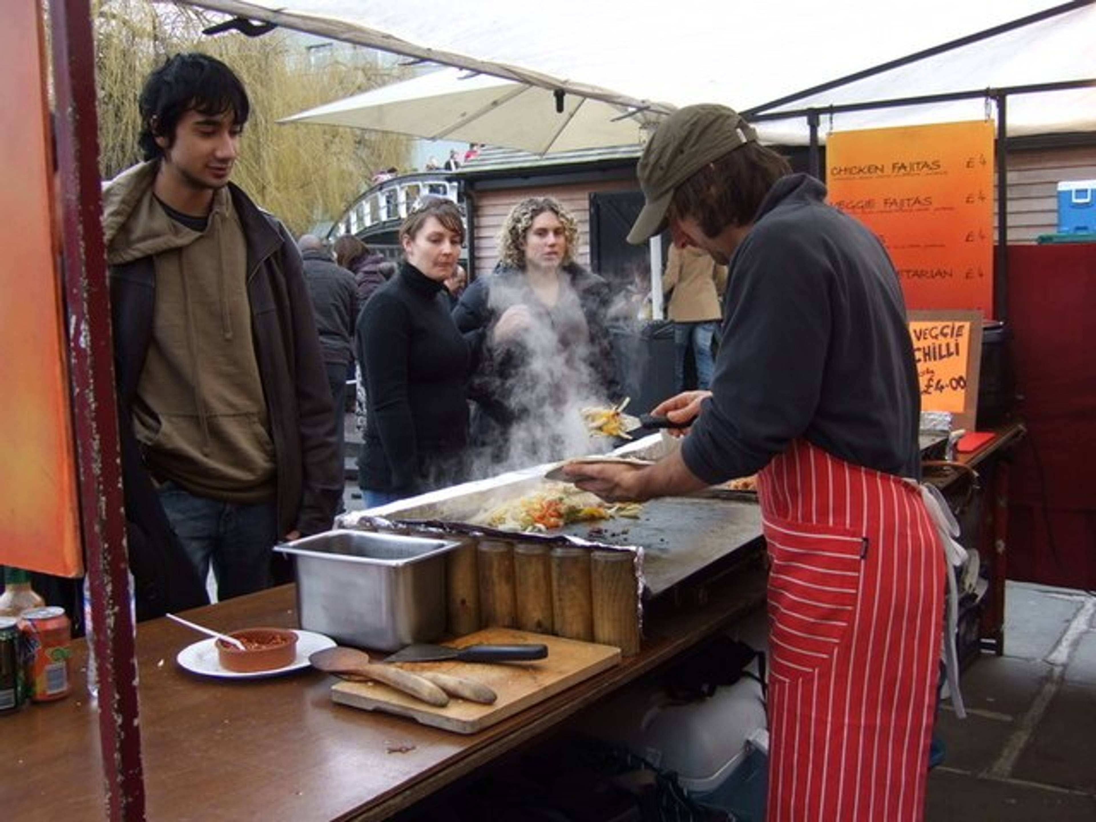 Woman cooking food at a stall in Camden