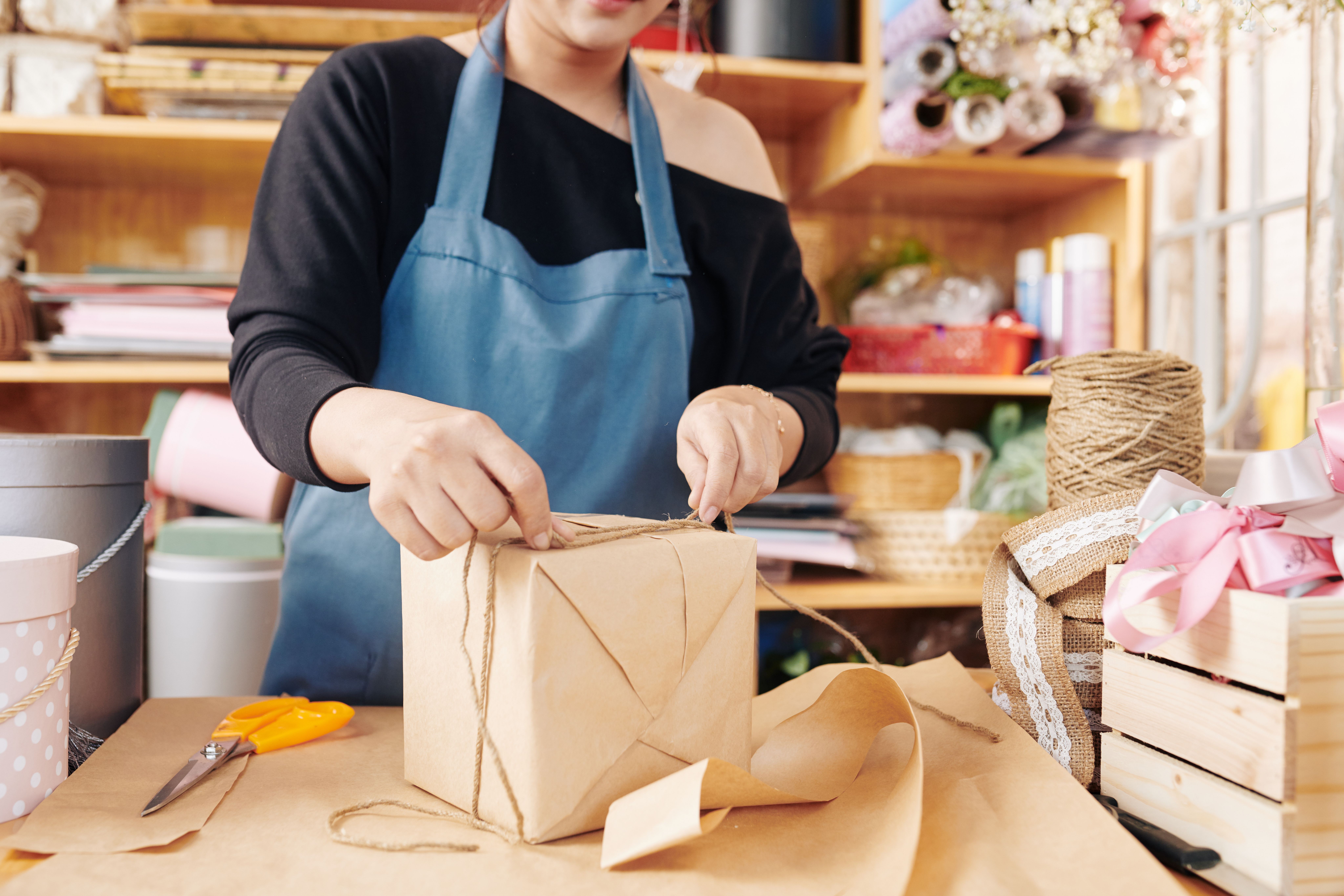 woman tying gift box with cord
