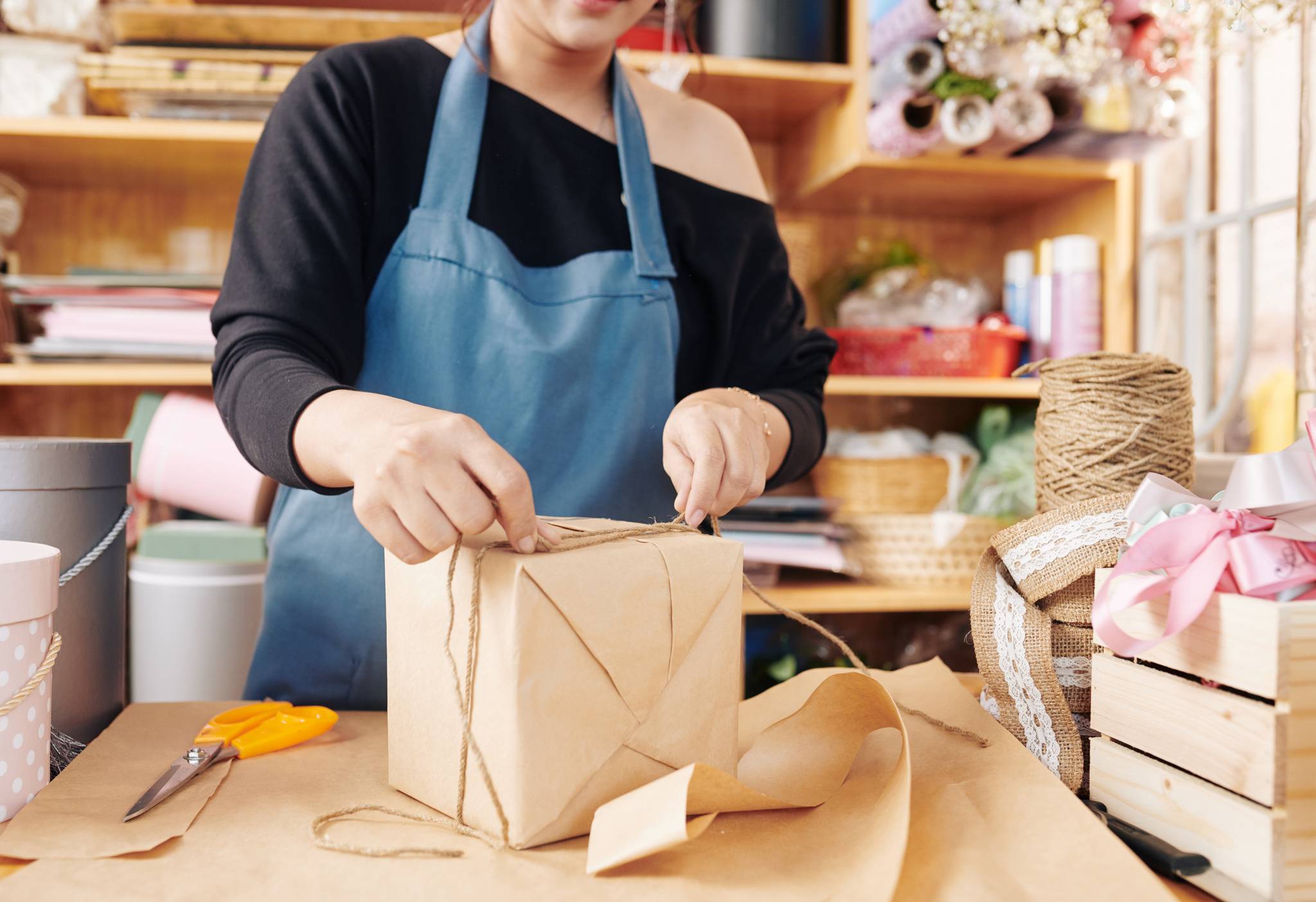 woman tying gift box with cord