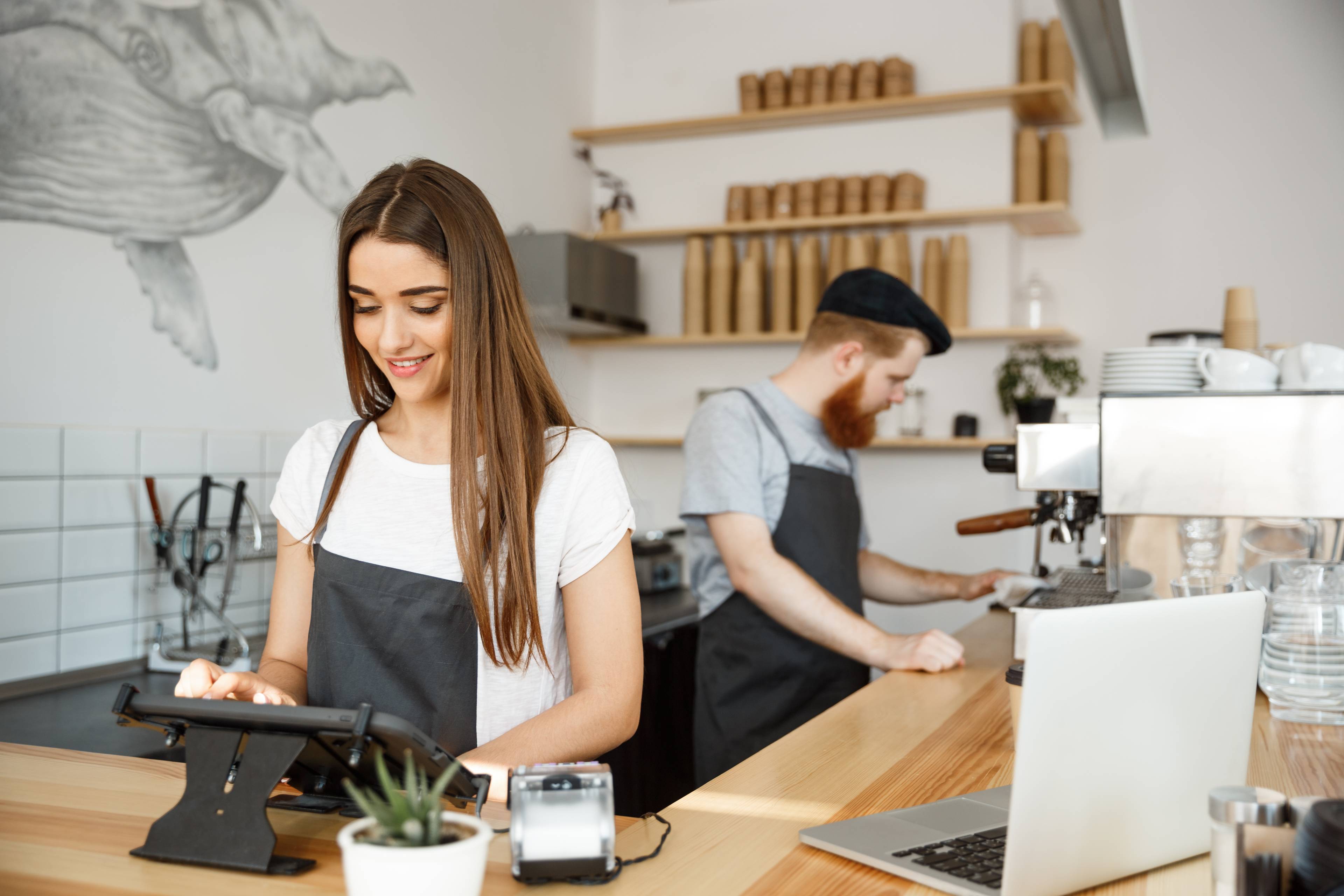 Man and woman smiling running business in coffee shop