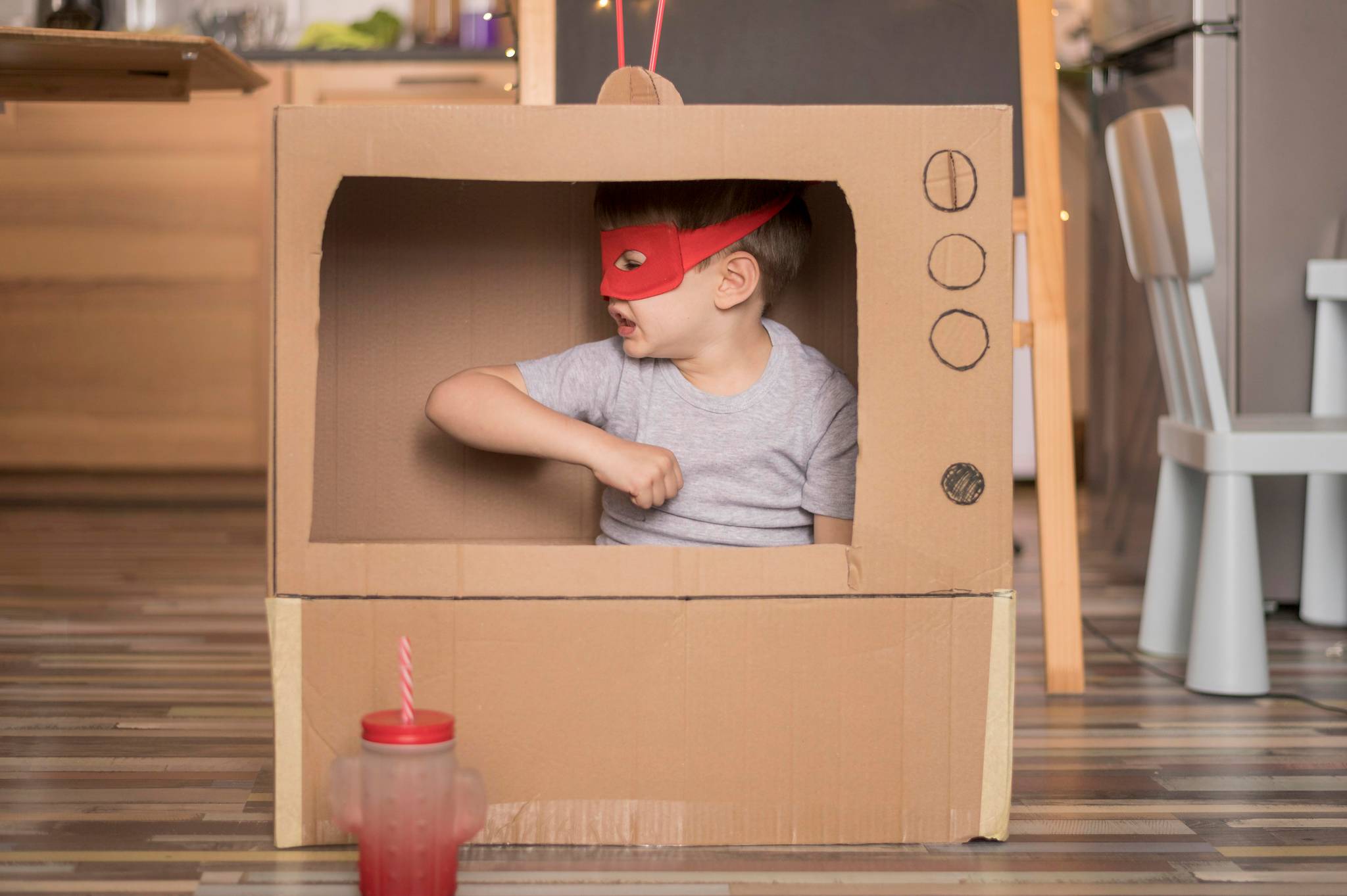 Boy acting inside cardboard TV