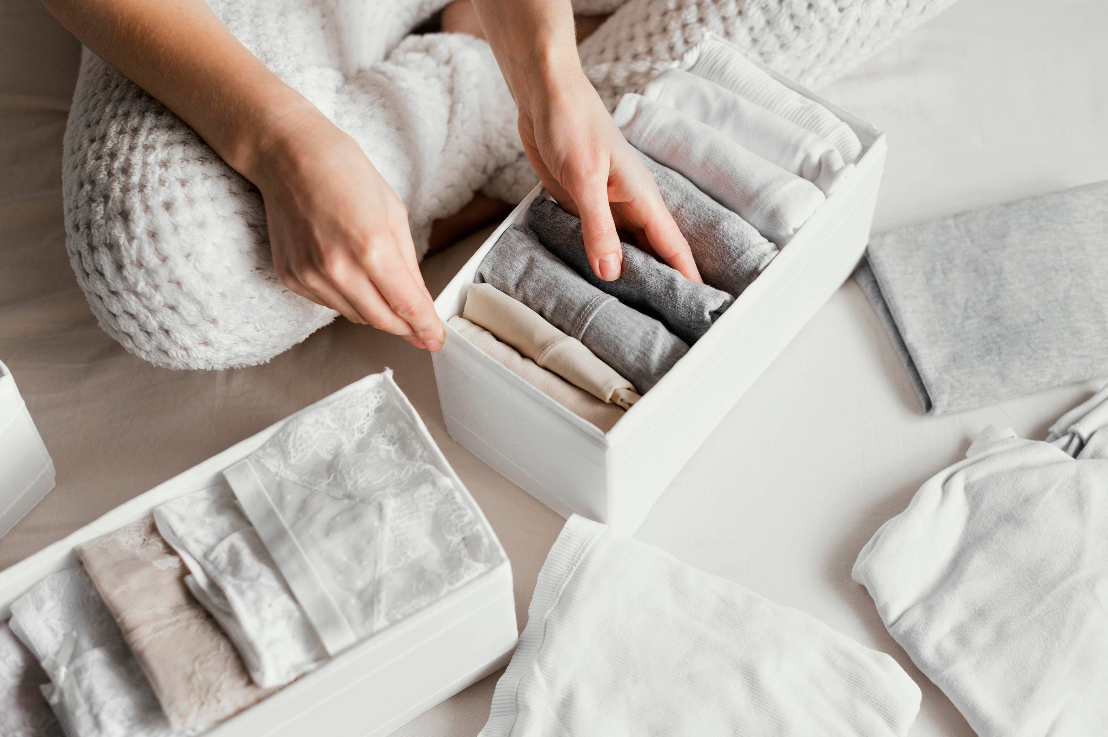 Women organizing clothes into small storage box