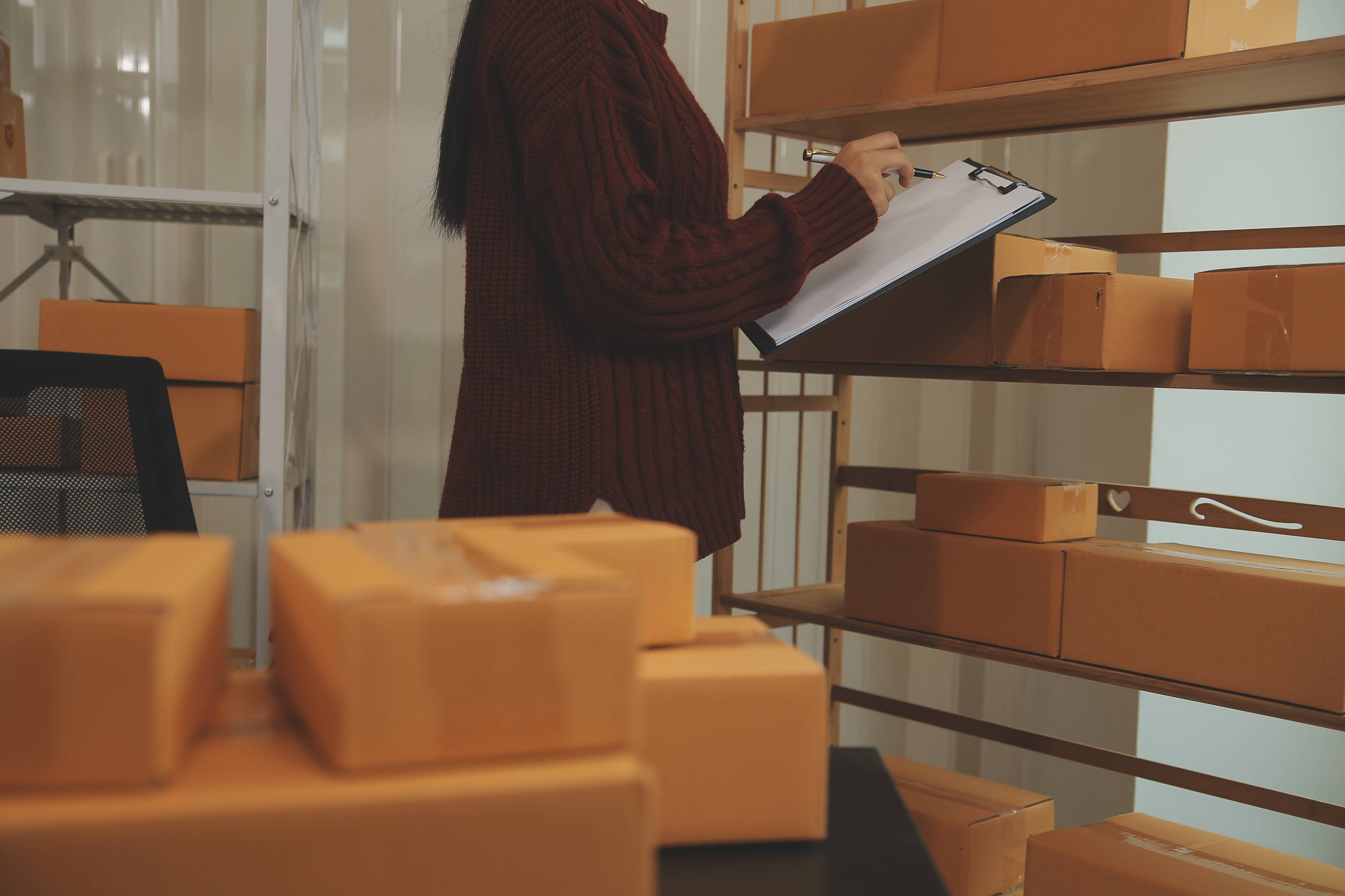 Young woman checking inventory in a small storage unit.