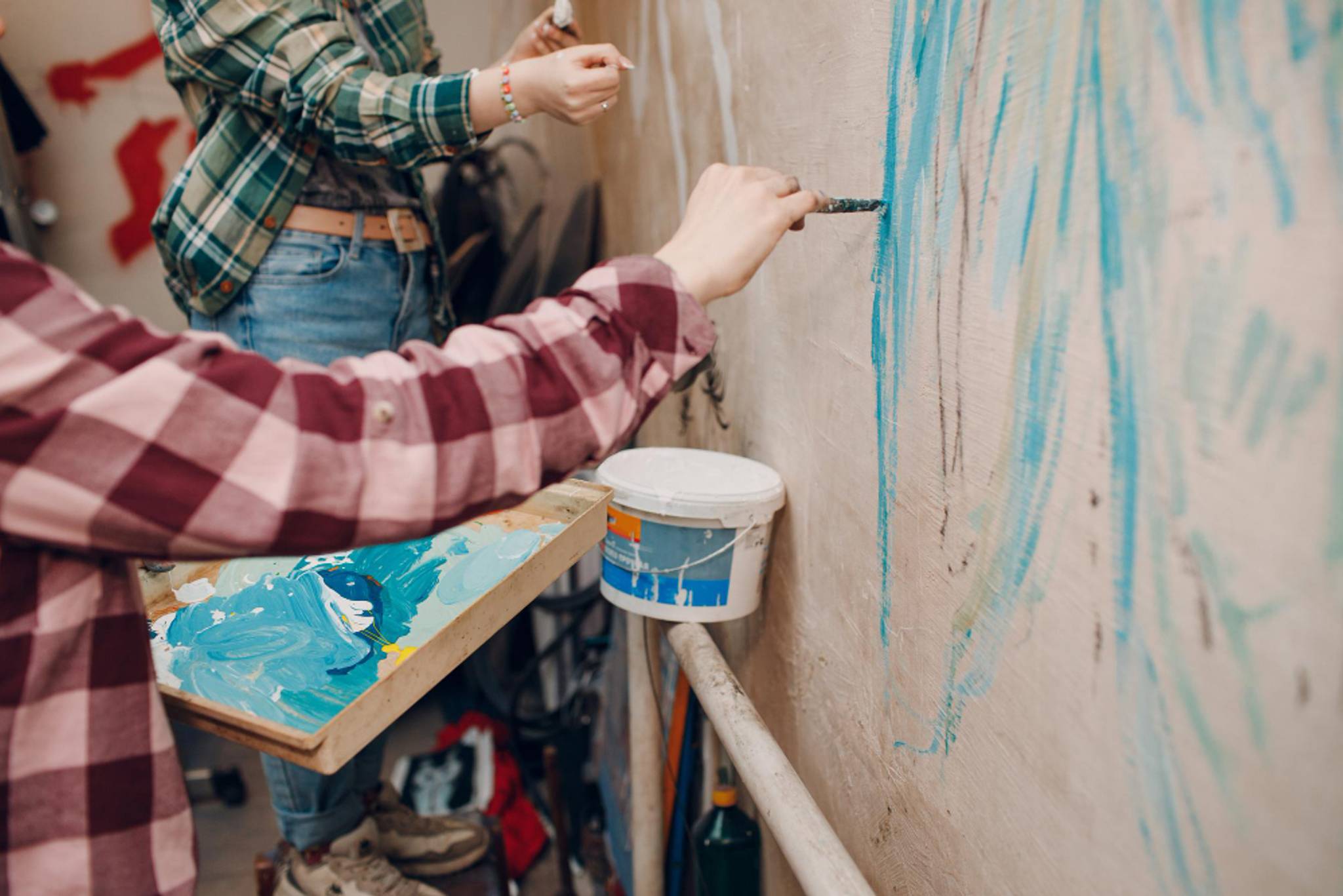 Man painting a wall with blue paint