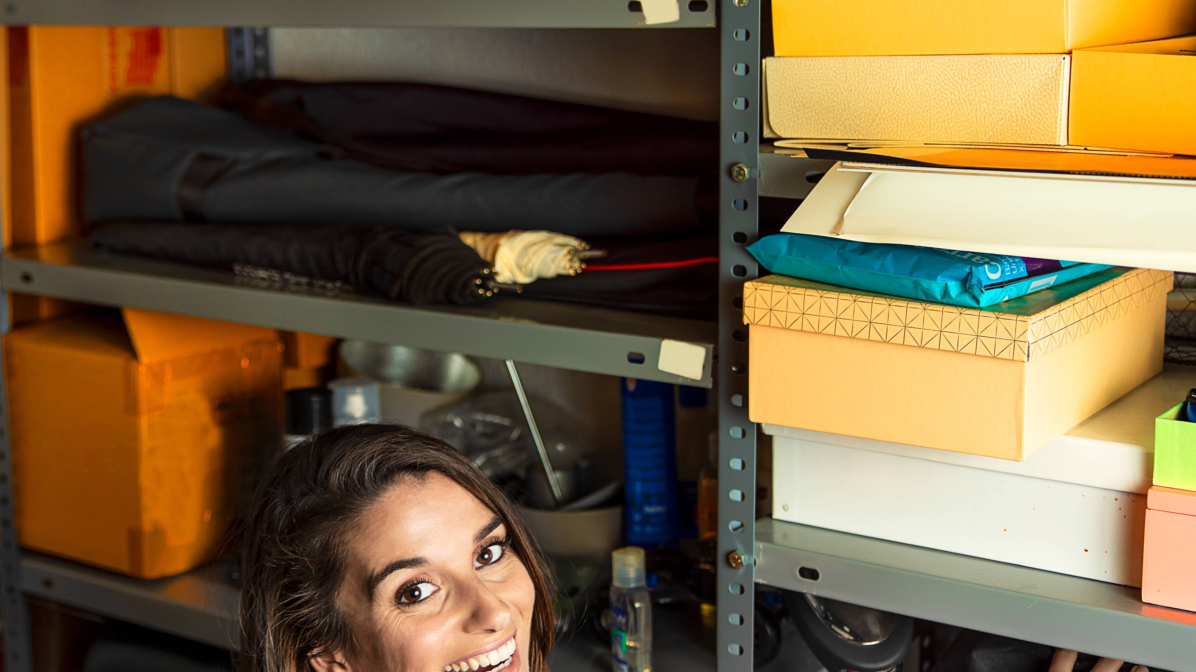 Woman standing next to shelf, organizing boxes