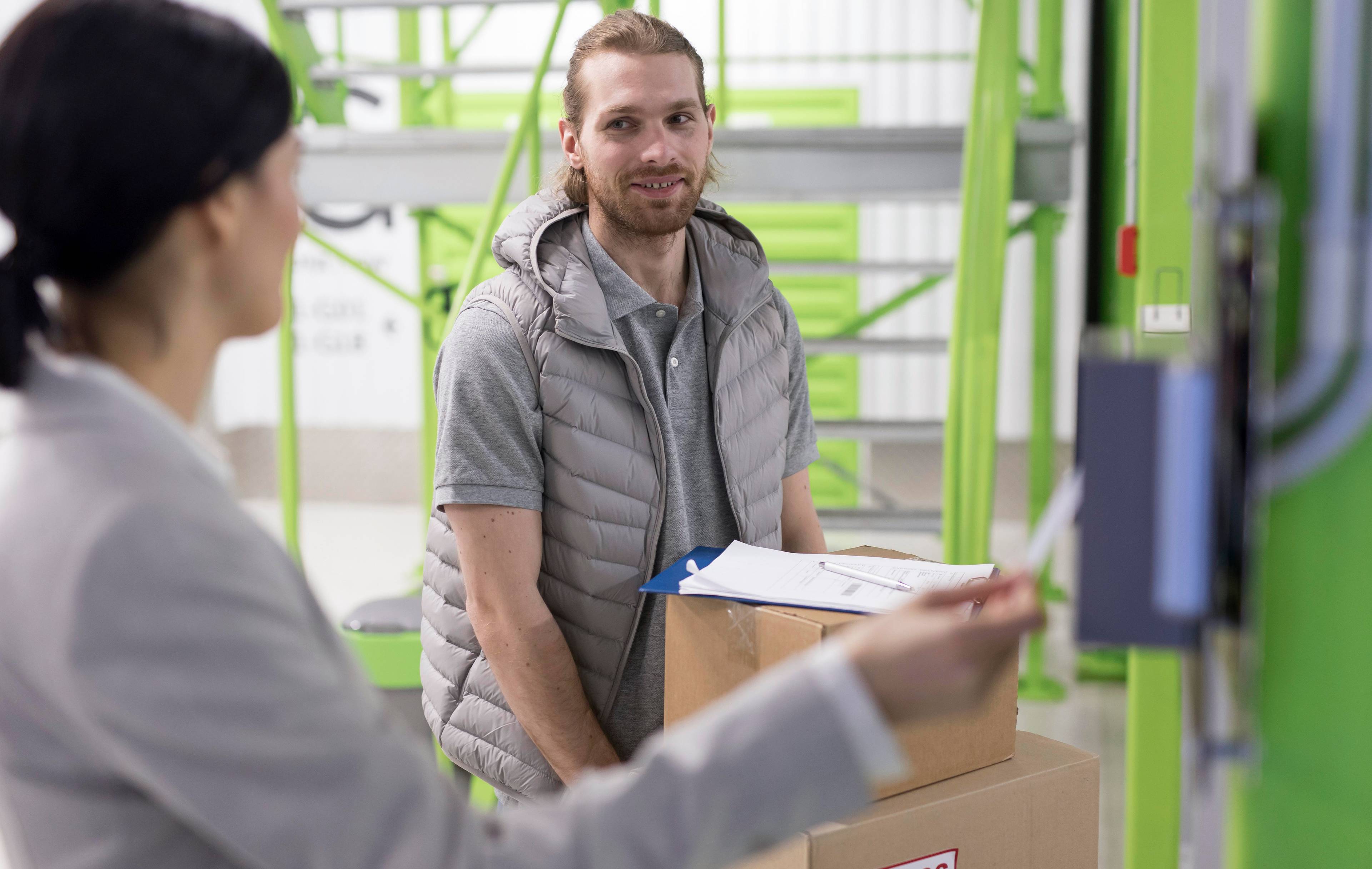 man and woman with boxes in facility