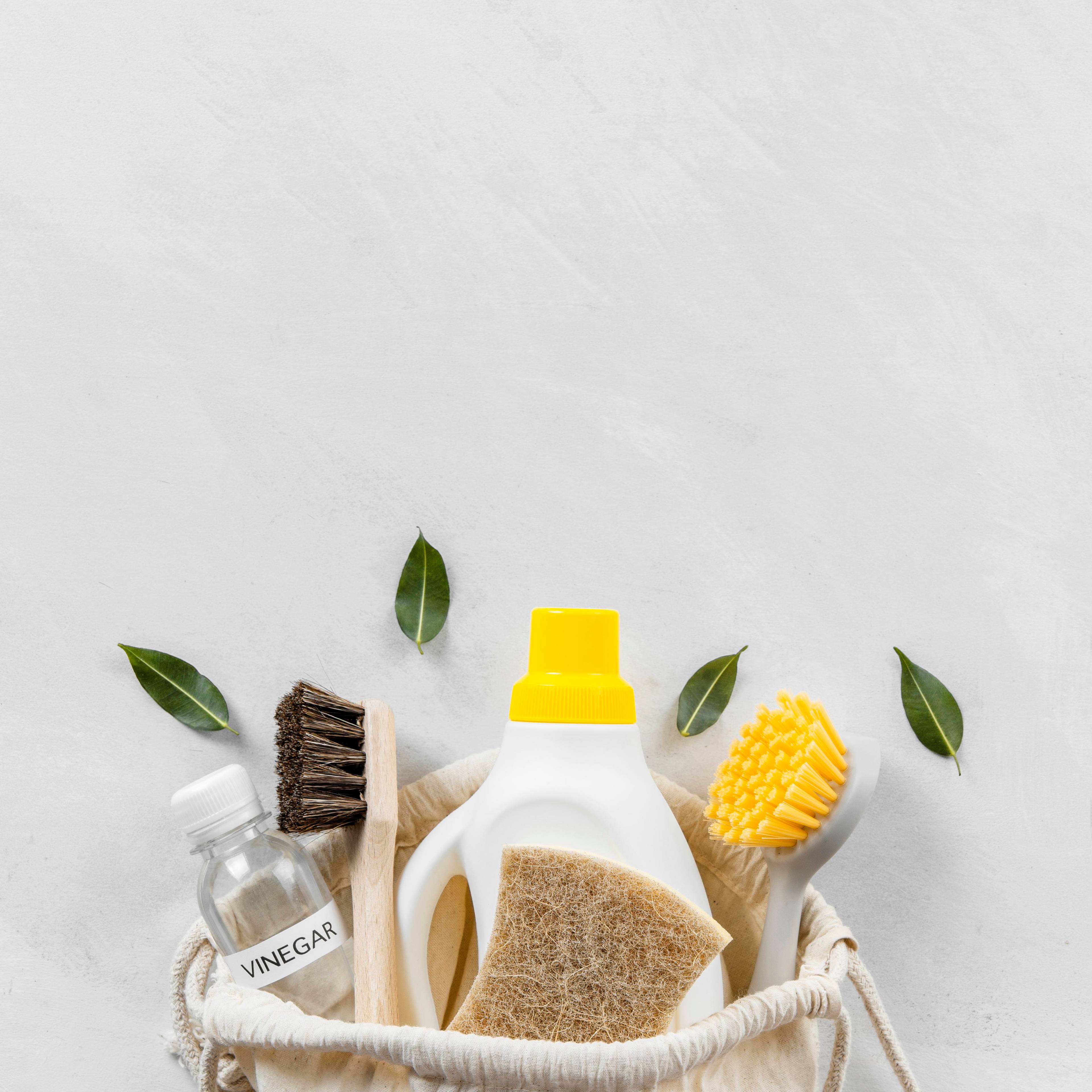 A set of cleaning materials in a basket with leaves as decoration