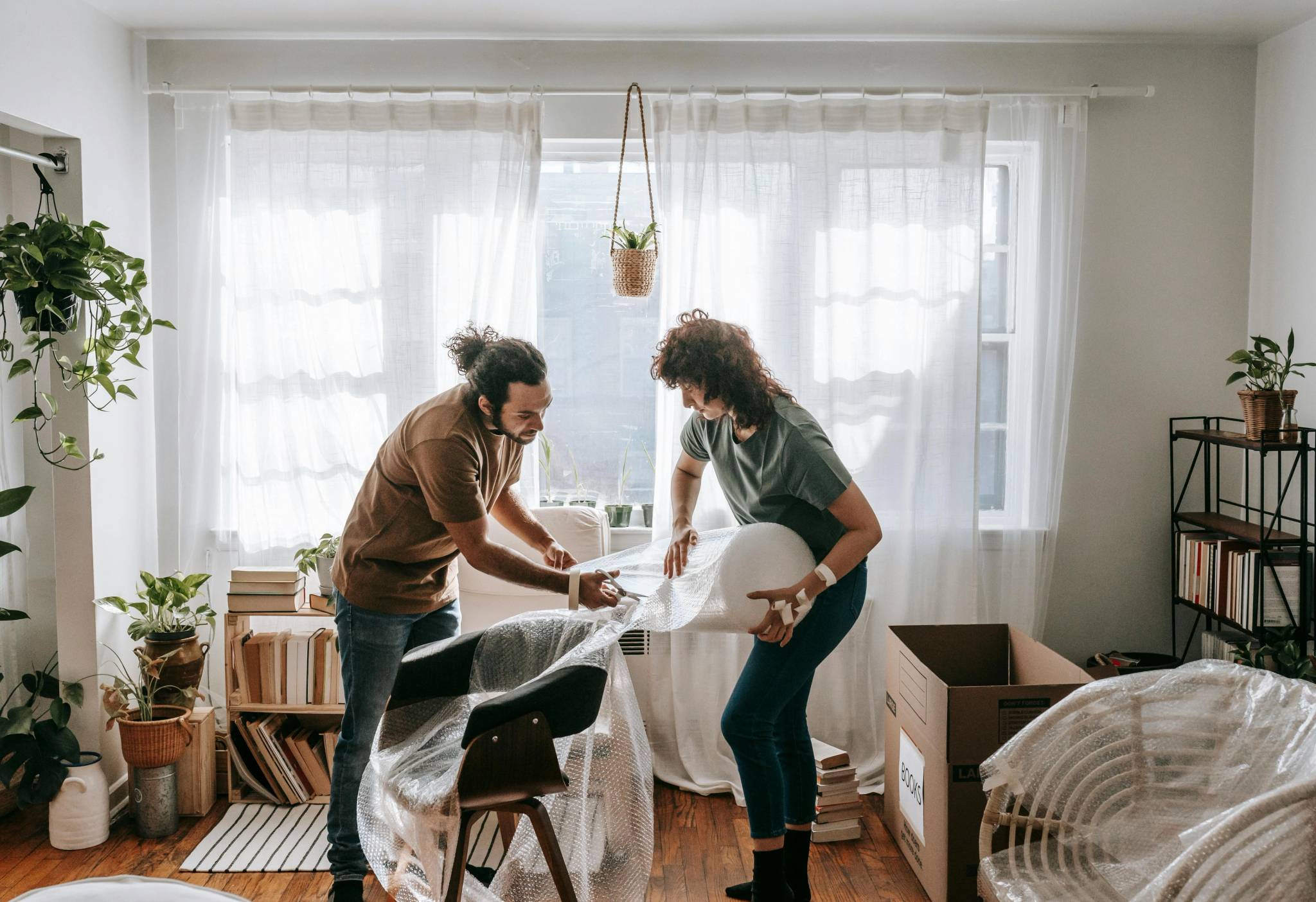 couple packing furniture to prepare for staging house for sale