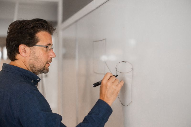 Reidar tegner bokser med streker mellom på tavle