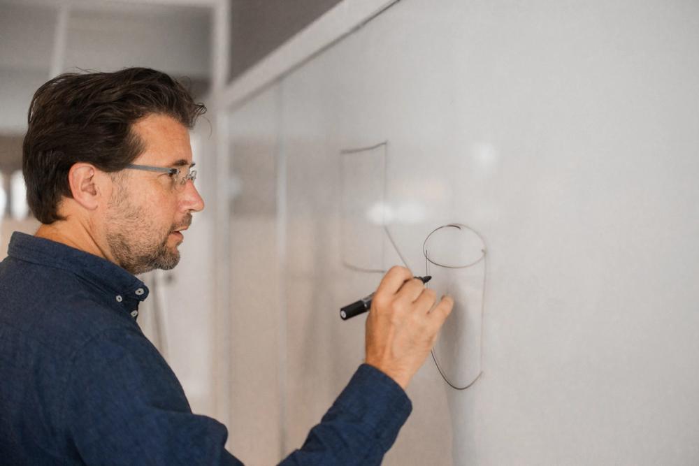 Reidar tegner bokser med streker mellom på tavle