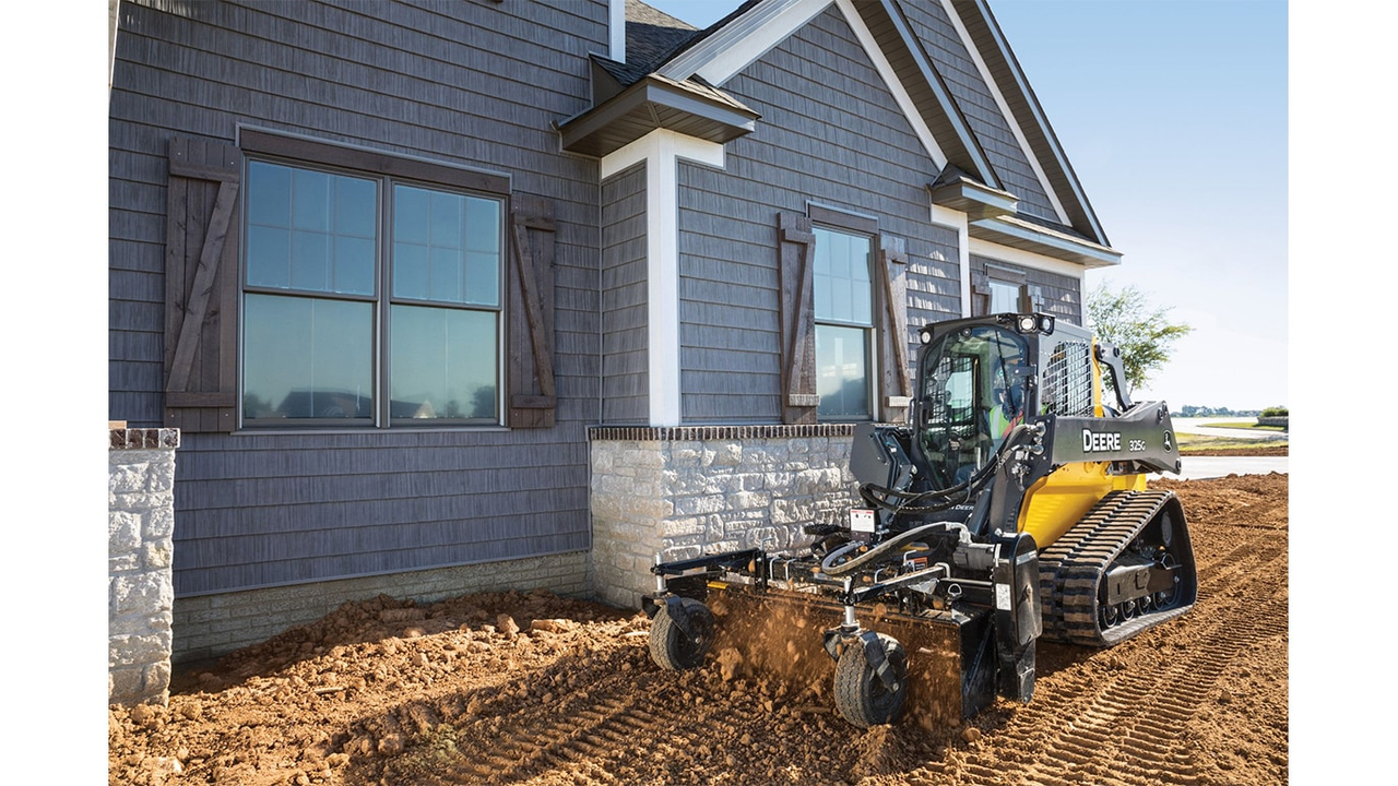 compact track loader performing grading work in tight landscaping