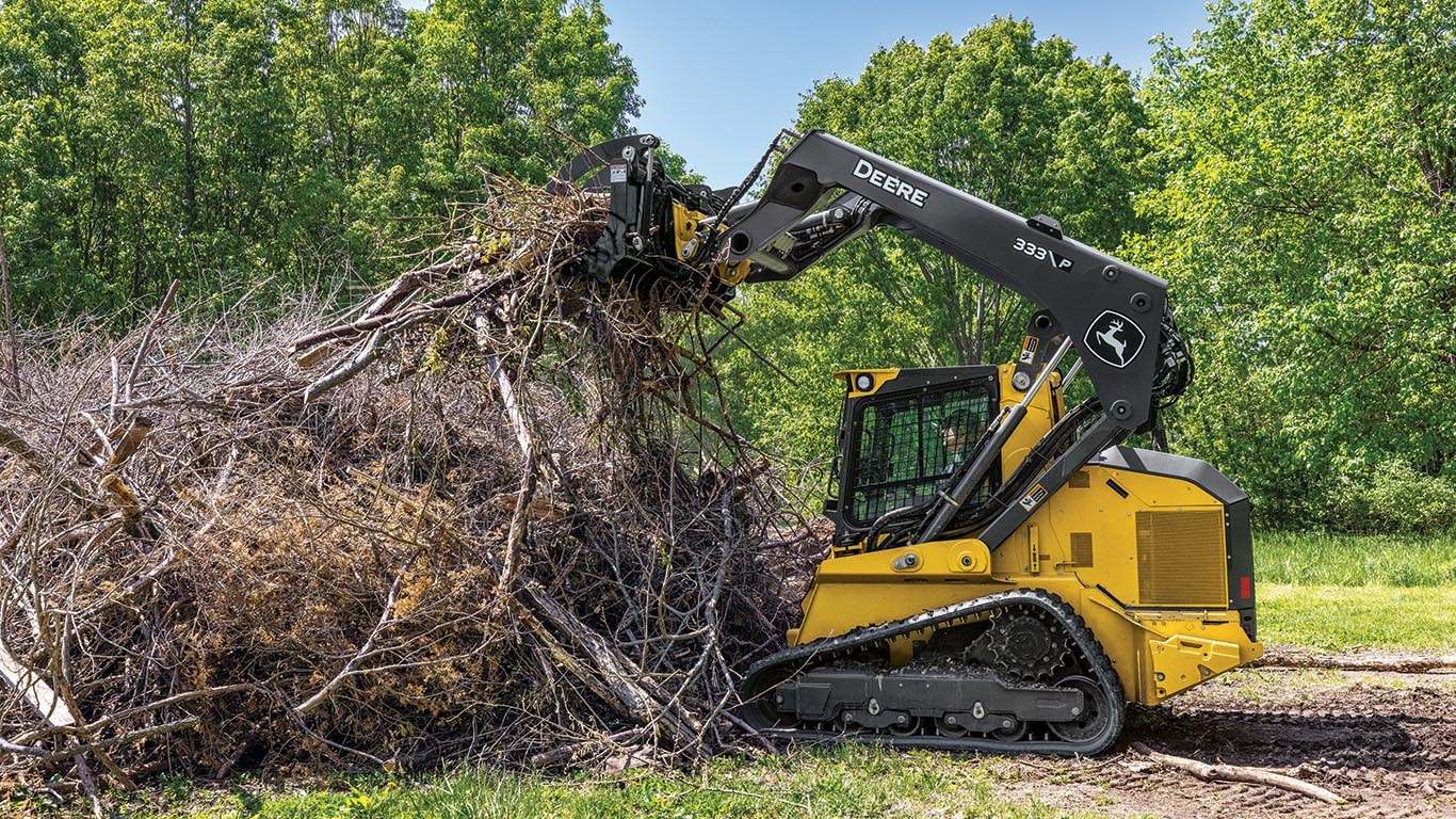 Skid steer forestry mulcher clearing brush