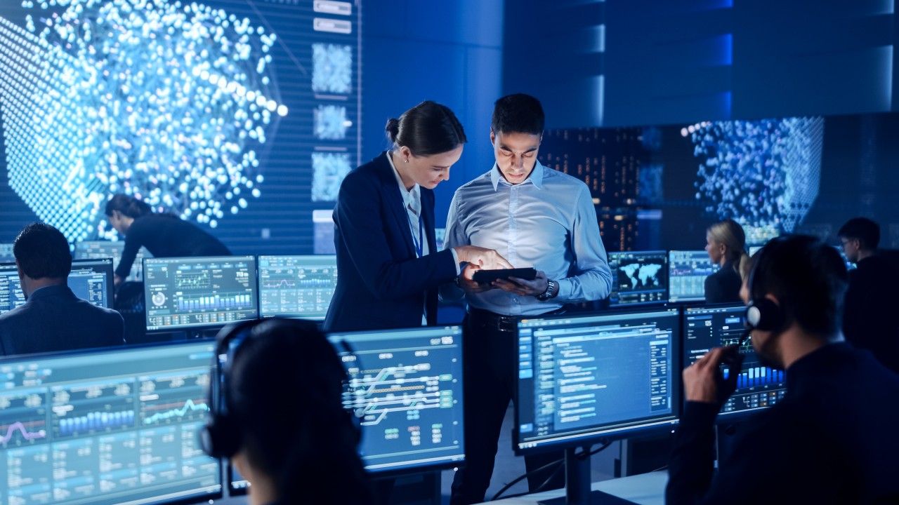 Two people implementing Zero Trust on connected devices.