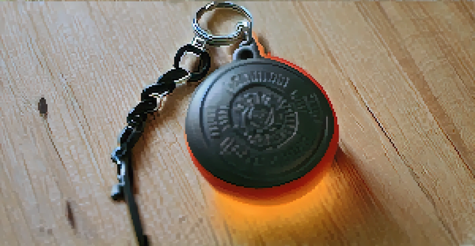 A close-up view of a DIY self-defense keychain with a hard rubber ball, resting on a wooden surface with soft lighting.