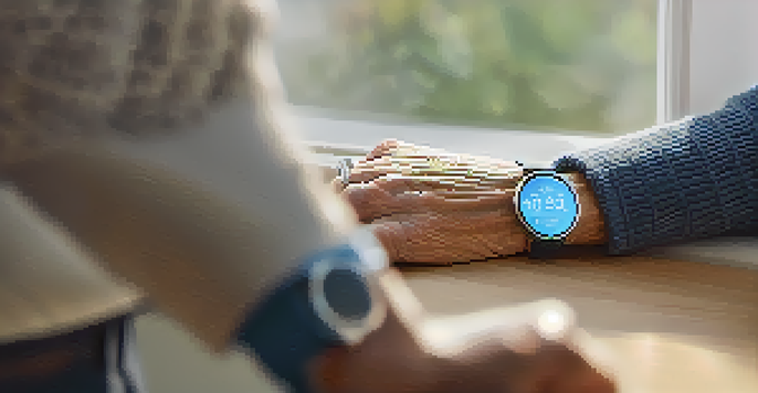An elderly person in a living room wearing a smartwatch that displays heart rate and has a panic button.