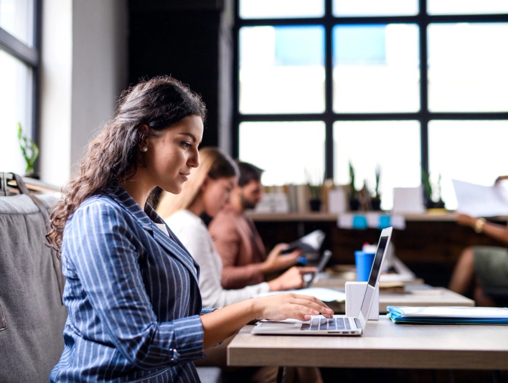Student intern working at a desk in an open plan office